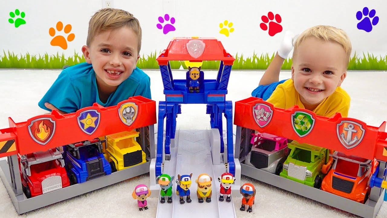 兩個男孩微笑著玩Paw Patrol玩具車和公仔。