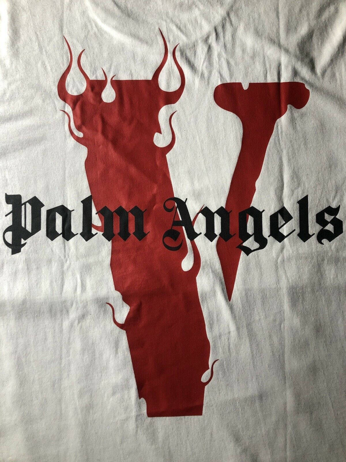 VLONE x Palm Angels 火紅標誌 壁紙 — 白色T恤上展示了一個大膽的紅色圖案，由風格化的魔鬼頭與字母V融合而成，上面覆蓋著黑色哥德式文字，寫著Palm Angels。