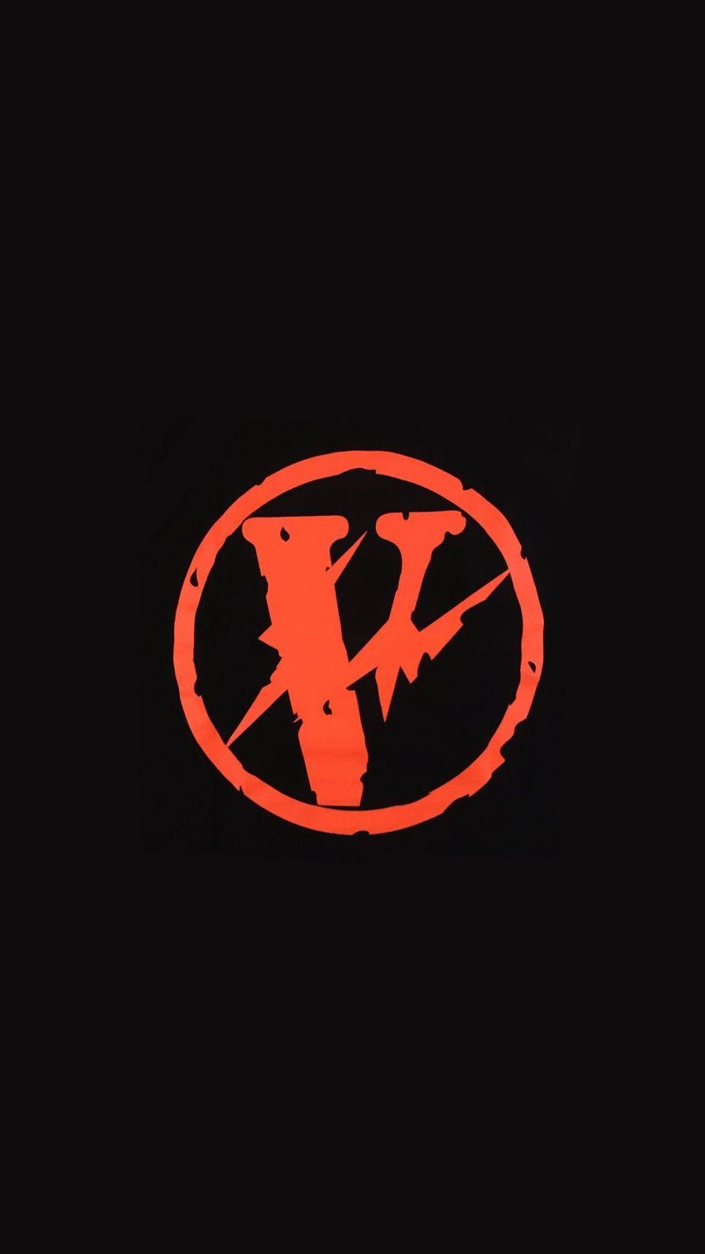 VLONE 橙色圓圈 壁紙 — 一個大膽的橙色風格化V符號在圓圈內，在純黑色背景上發光。