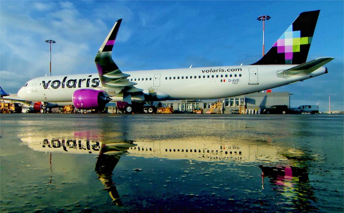 Volaris飛機在機場濕滑停機坪上的倒影