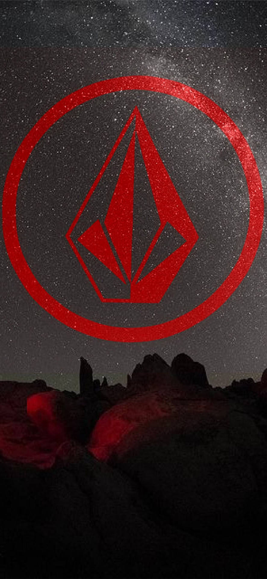 紅色Volcom標誌在繁星點點的夜空下，在沙漠岩石上方發光。