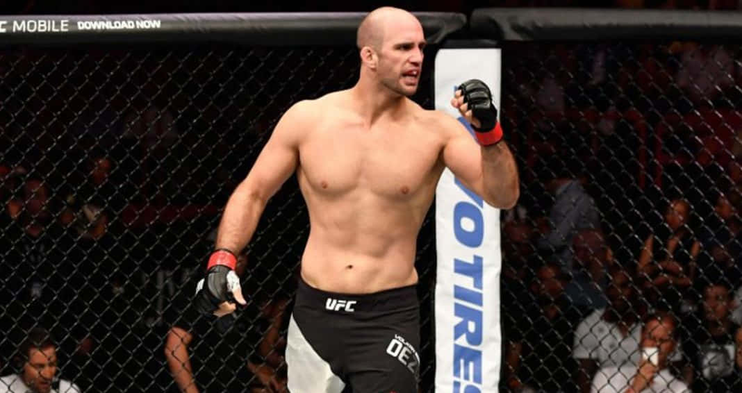一個光頭MMA戰士在UFC八角籠內慶祝勝利，粉絲歡呼。