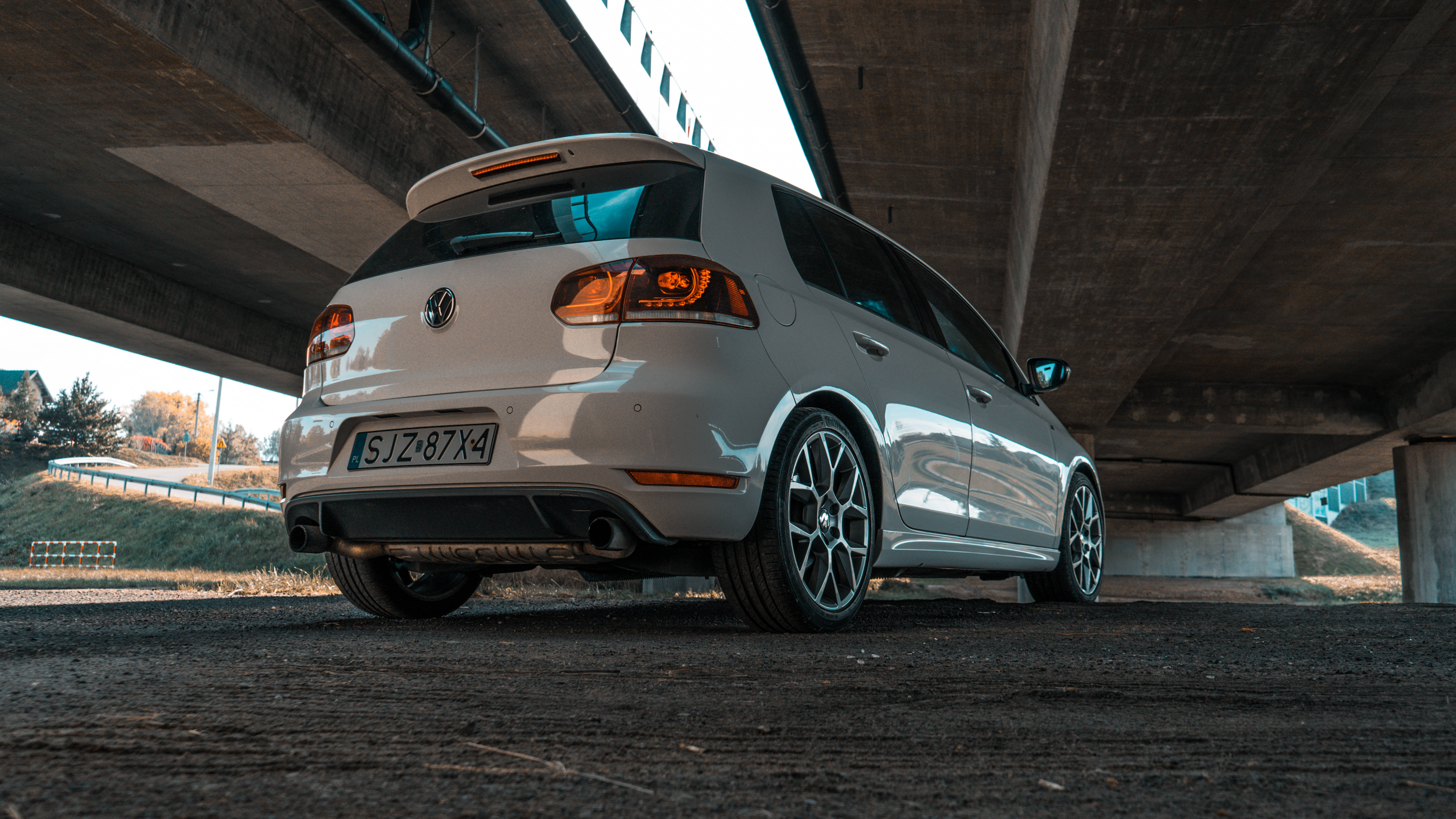 Volkswagen Golf GTI Mk6 高架橋下 壁紙 — 一輛銀色福士 Golf R 停泊在混凝土天橋下，發光的尾燈在其流線型車身上反射。