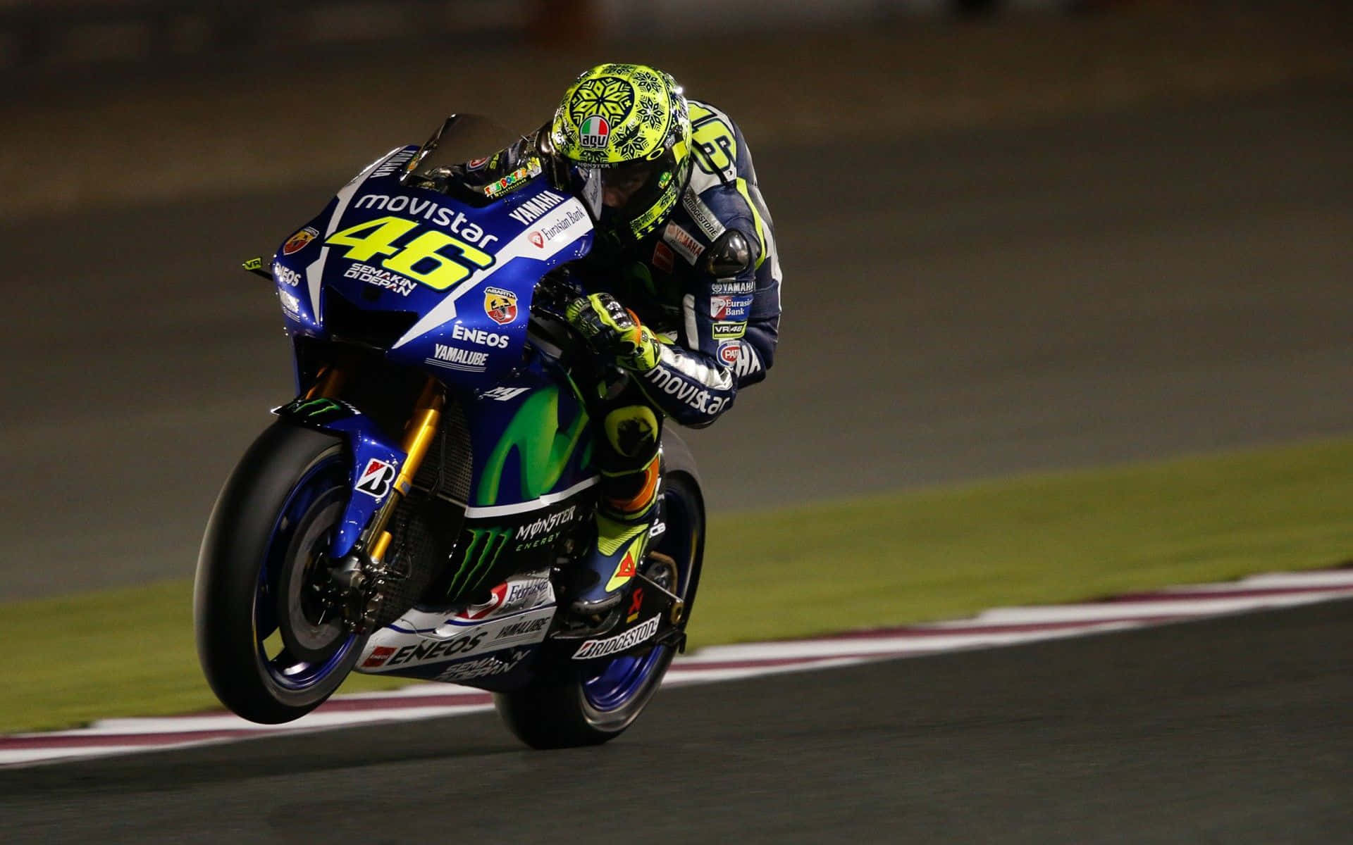 VR46 2015卡塔爾MotoGP冠軍 壁紙 — 電單車車手在夜間賽道上，在明亮的體育場燈光下傾斜入彎。