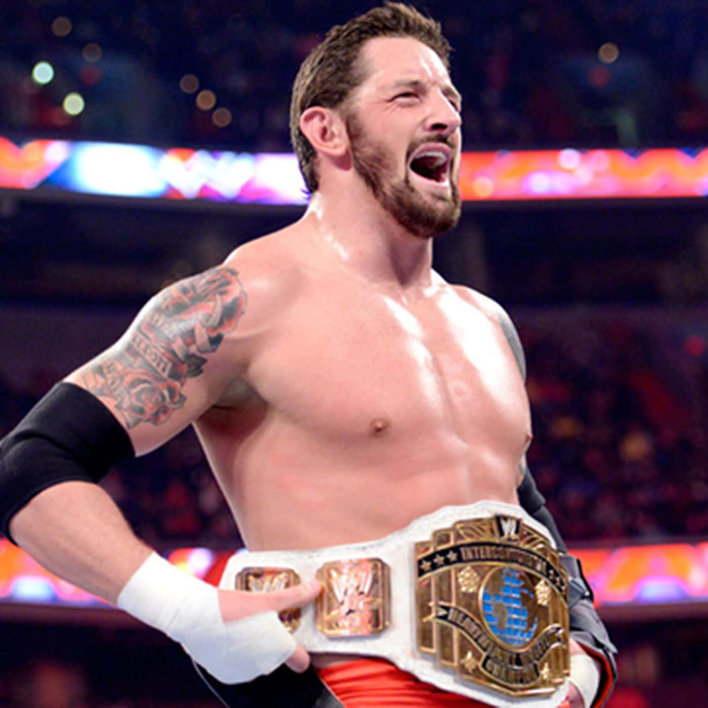 Wade Barrett 展示腰帶 壁紙 — 一位肌肉發達、有紋身的摔角手在燈光明亮的競技場中高舉冠軍腰帶，發出勝利的咆哮。