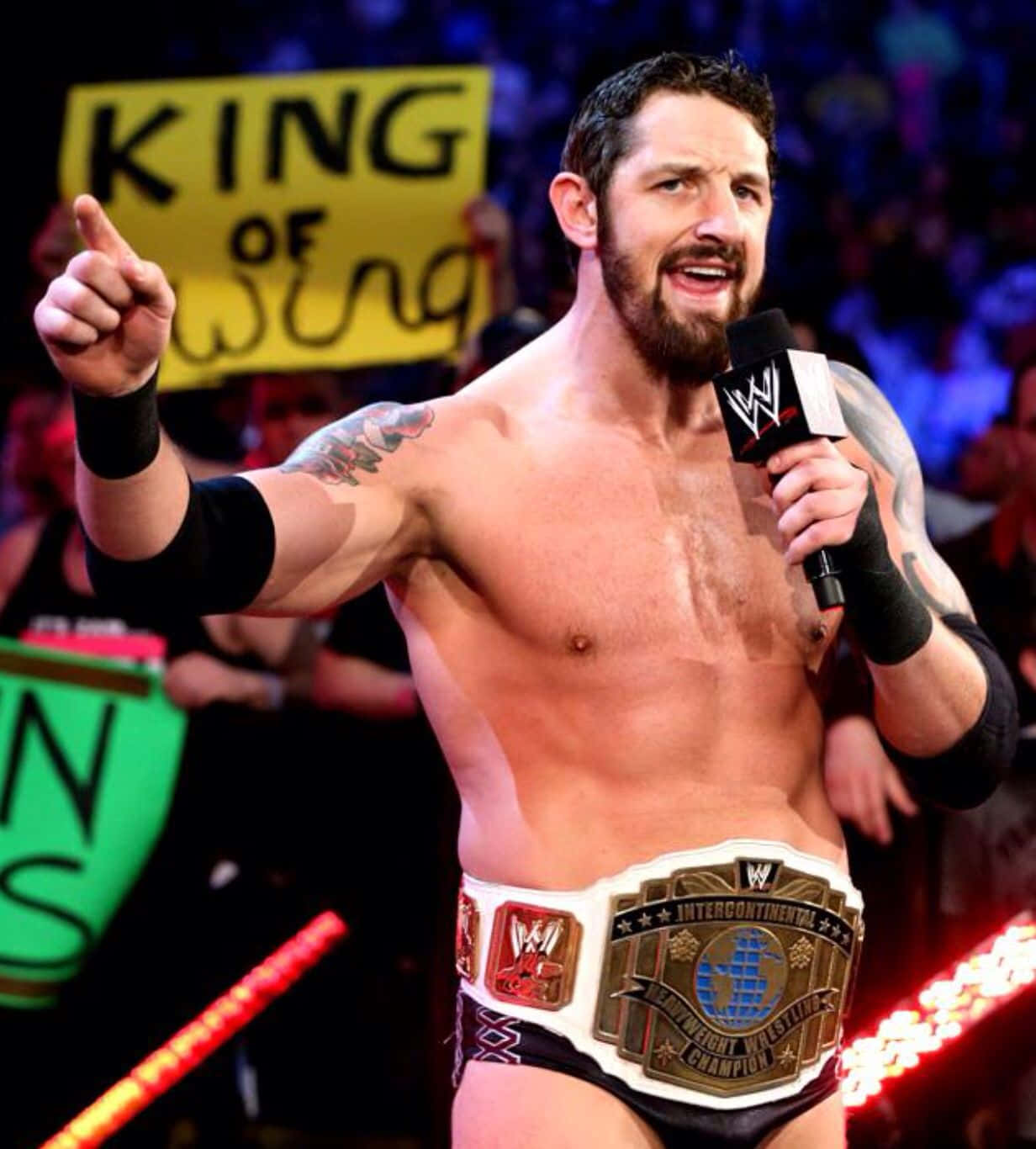 Wade Barrett 營造熱情氛圍 壁紙 — 一位肌肉發達、留鬍鬚的WWE摔角手，手持冠軍腰帶和咪高峰，勝利地指向人群。