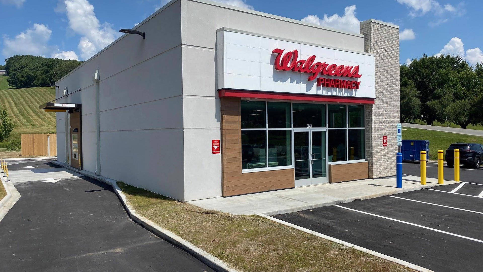 Walgreens藥房店面，設有停車場，背景是綠色山丘。