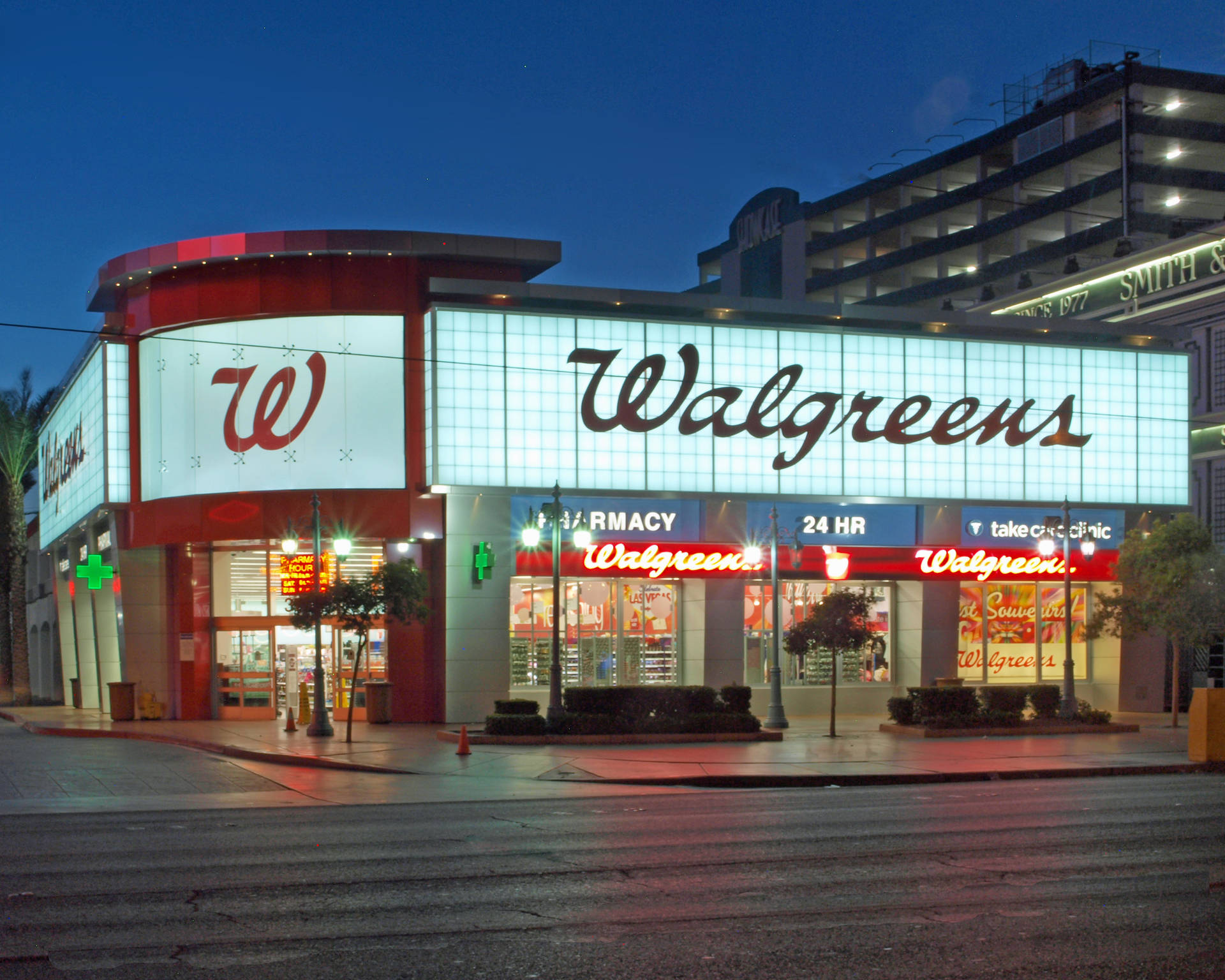 夜晚的Walgreens藥房，發光招牌和潮濕人行道反射光線。
