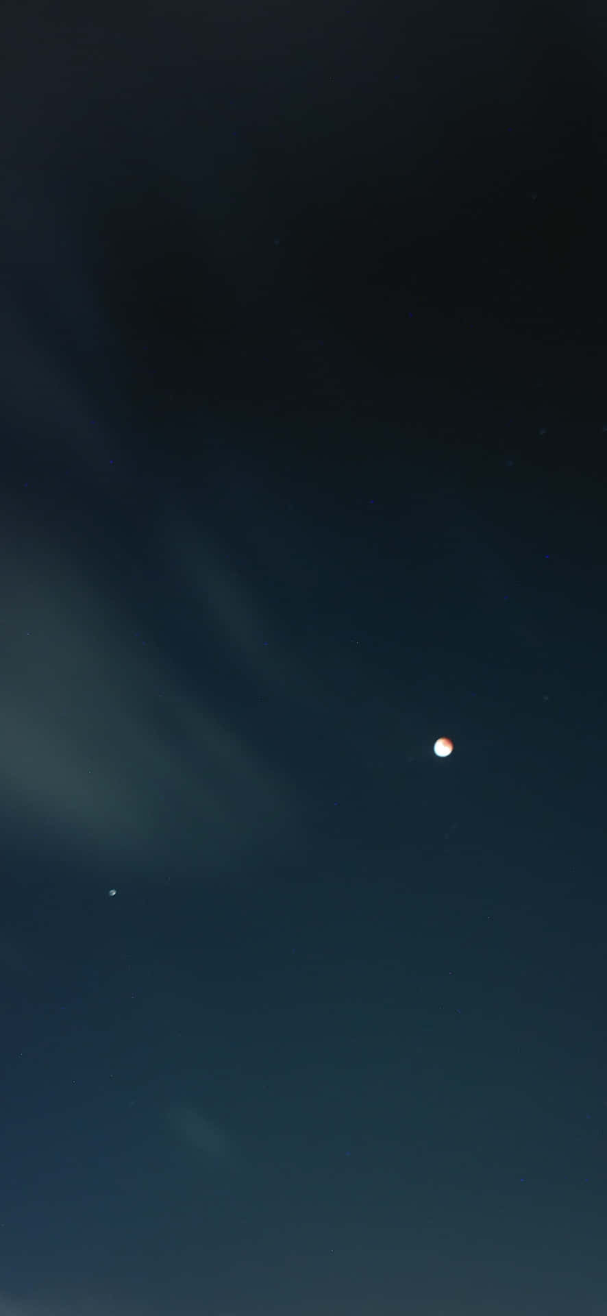 一顆發光的行星在帶有縷縷雲彩的深靛藍色夜空中閃耀。
