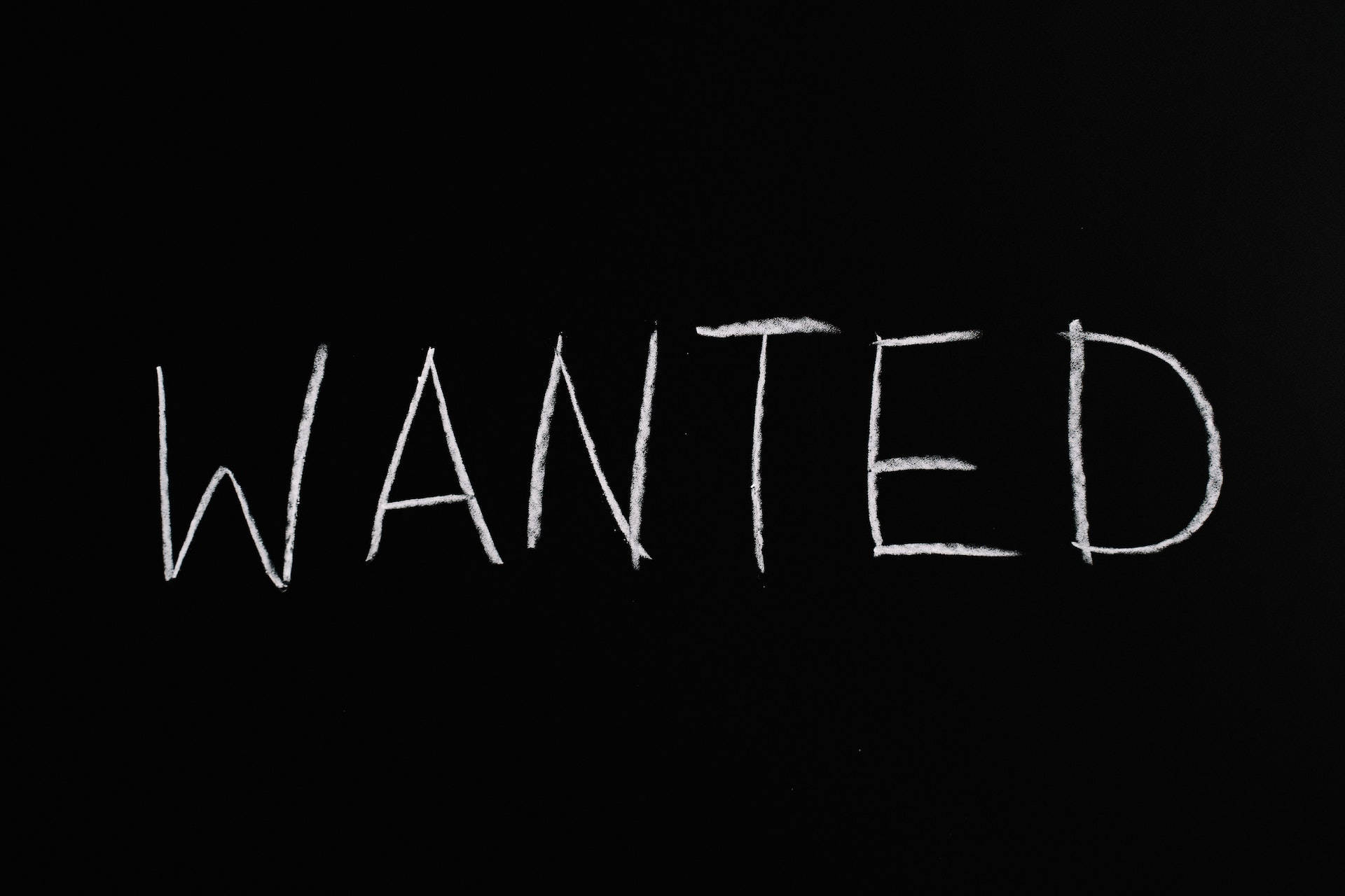 黑色動態圖 桌布 壁紙 — 「WANTED」呢個字用白色粉筆粗魯咁寫喺黑板表面。