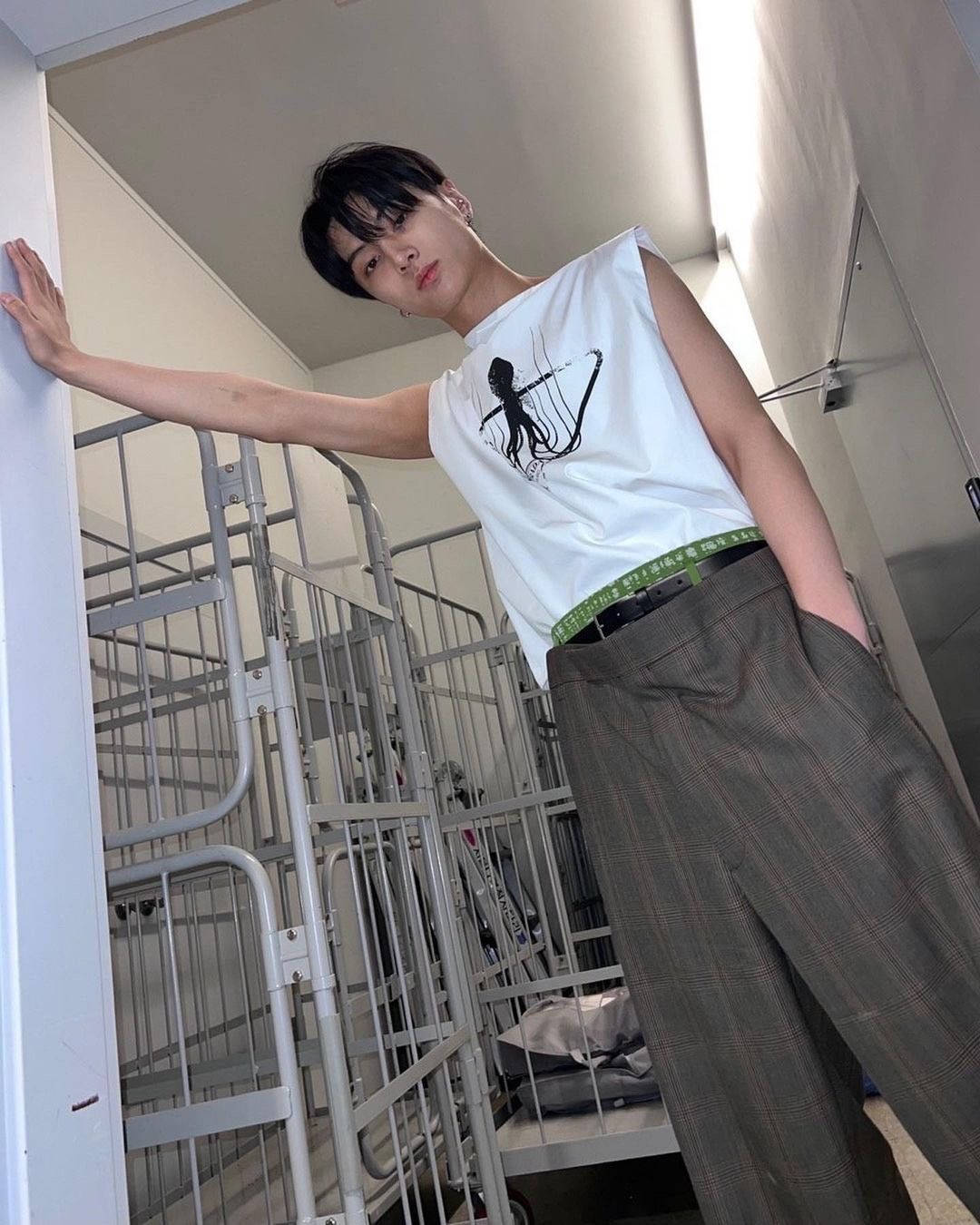 年輕男子在設有金屬雙層床的宿舍房間裡擺姿勢。