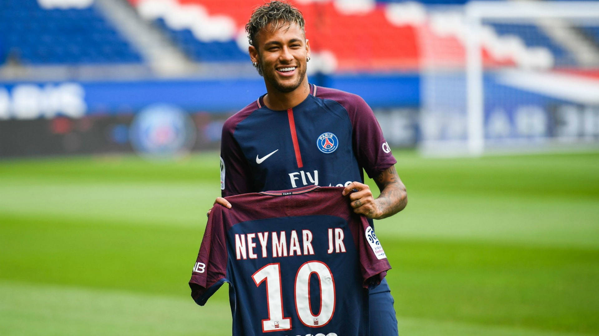 尼馬微笑著在足球場上拿著他的PSG 10號球衣。