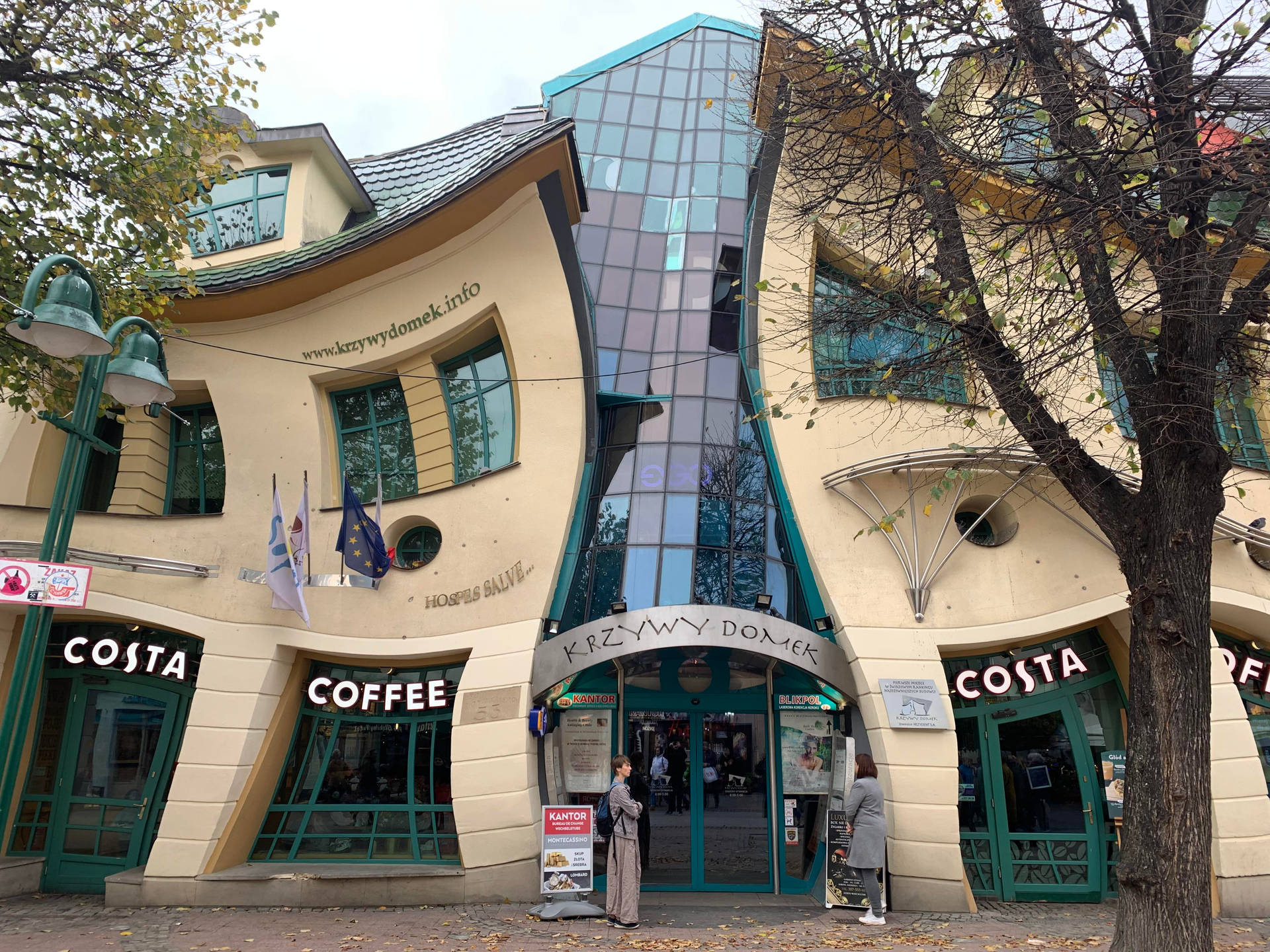 彎曲的現代建築，設有 Costa Coffee 店和秋樹。