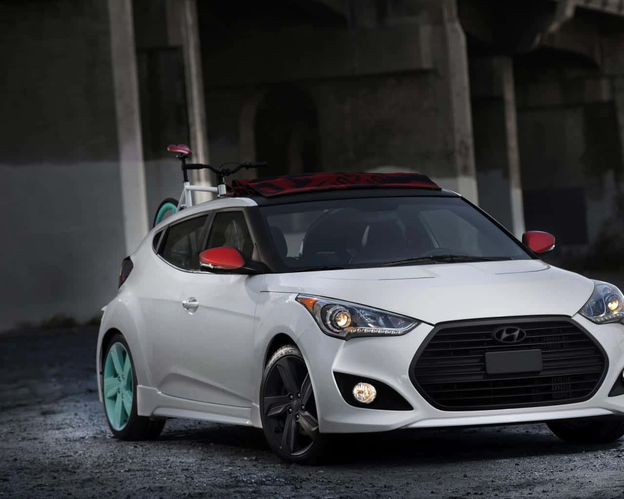 Hyundai Veloster 桌布 壁紙 — 一輛白色現代Veloster，配薄荷綠色車輪，車頂載著一輛紅色單車，停泊在混凝土天橋下。