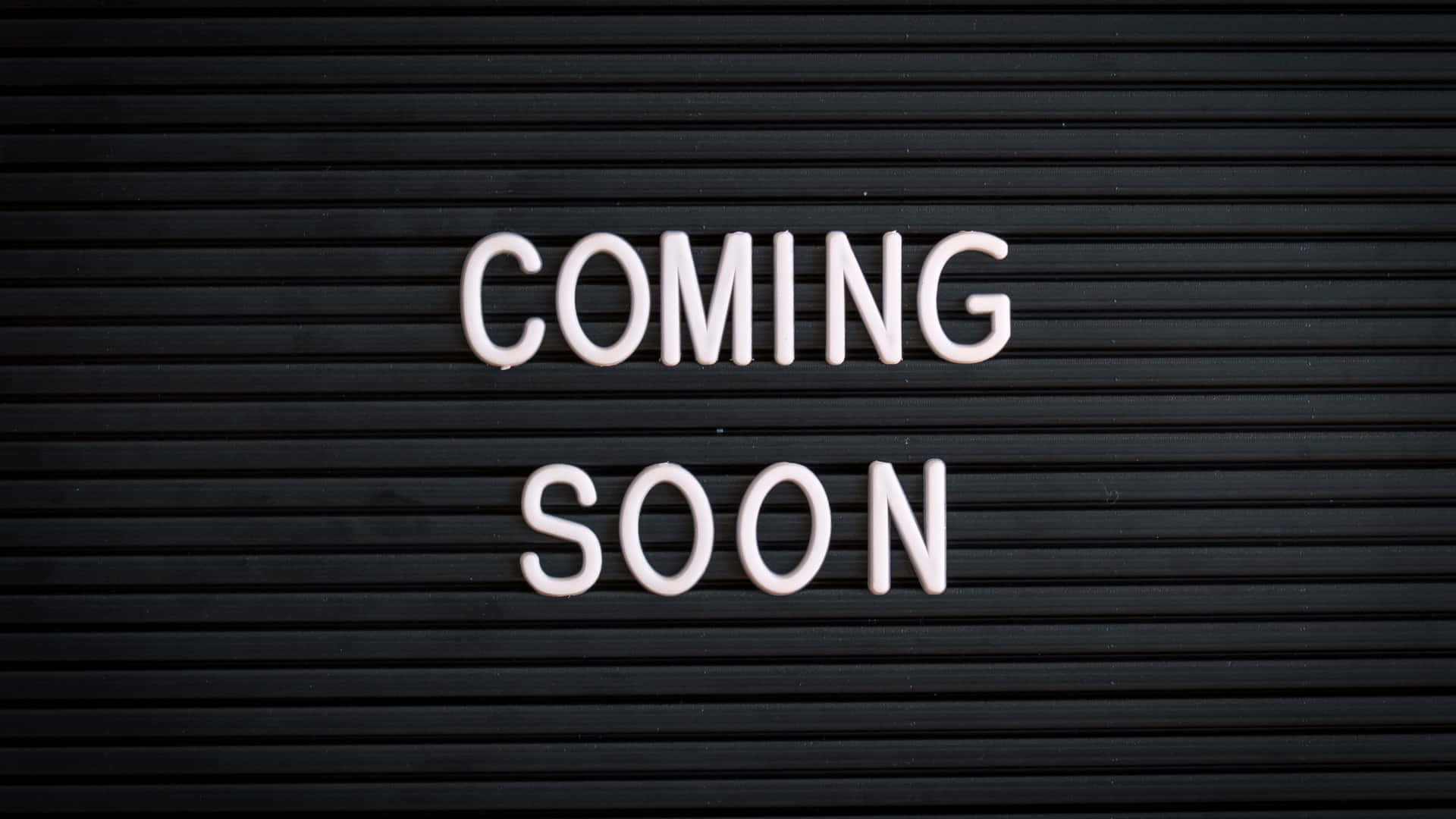 黑色板上的白色字母寫著coming soon