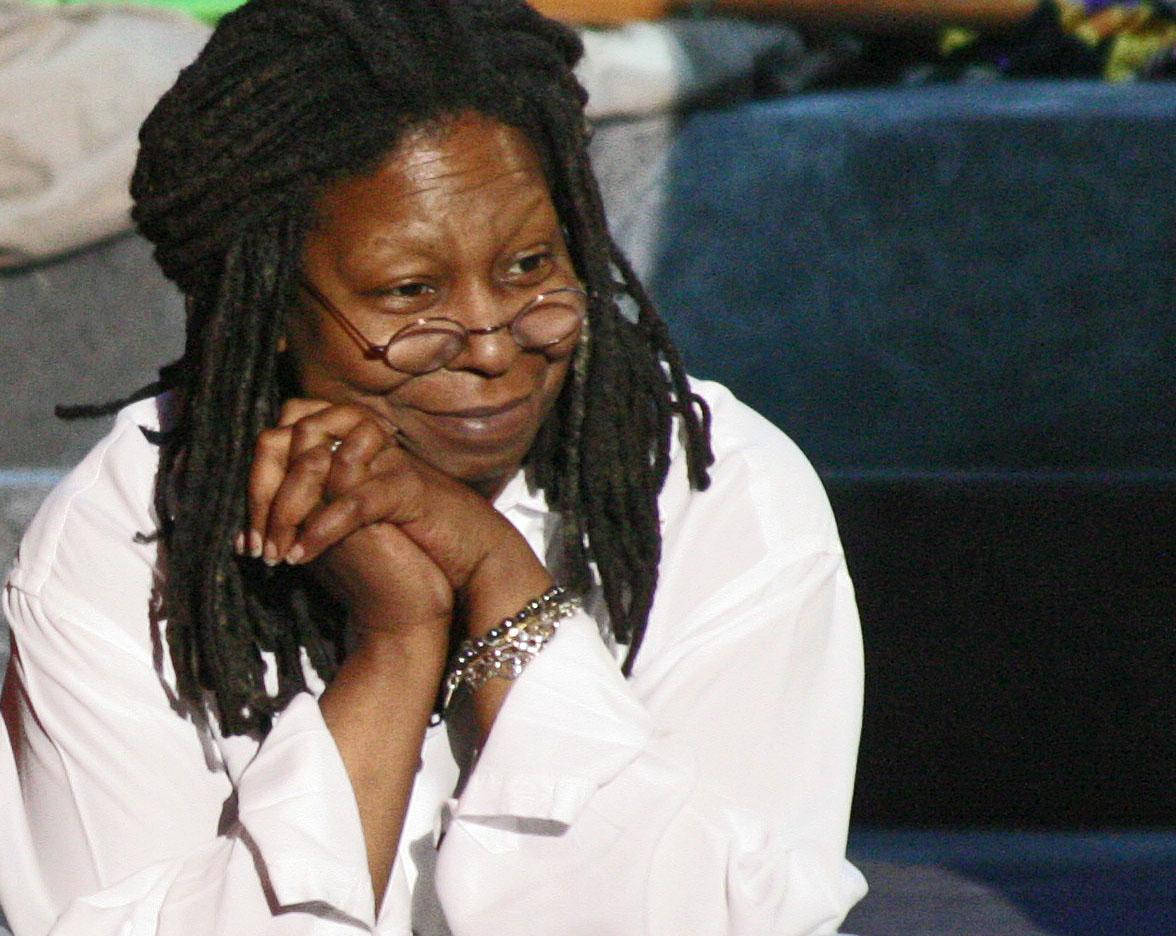 Whoopi Goldberg 穿白色襯衫 壁紙 — 一位擁有深色辮子頭和眼鏡的女性，穿著白色襯衫，將下巴靠在手上。