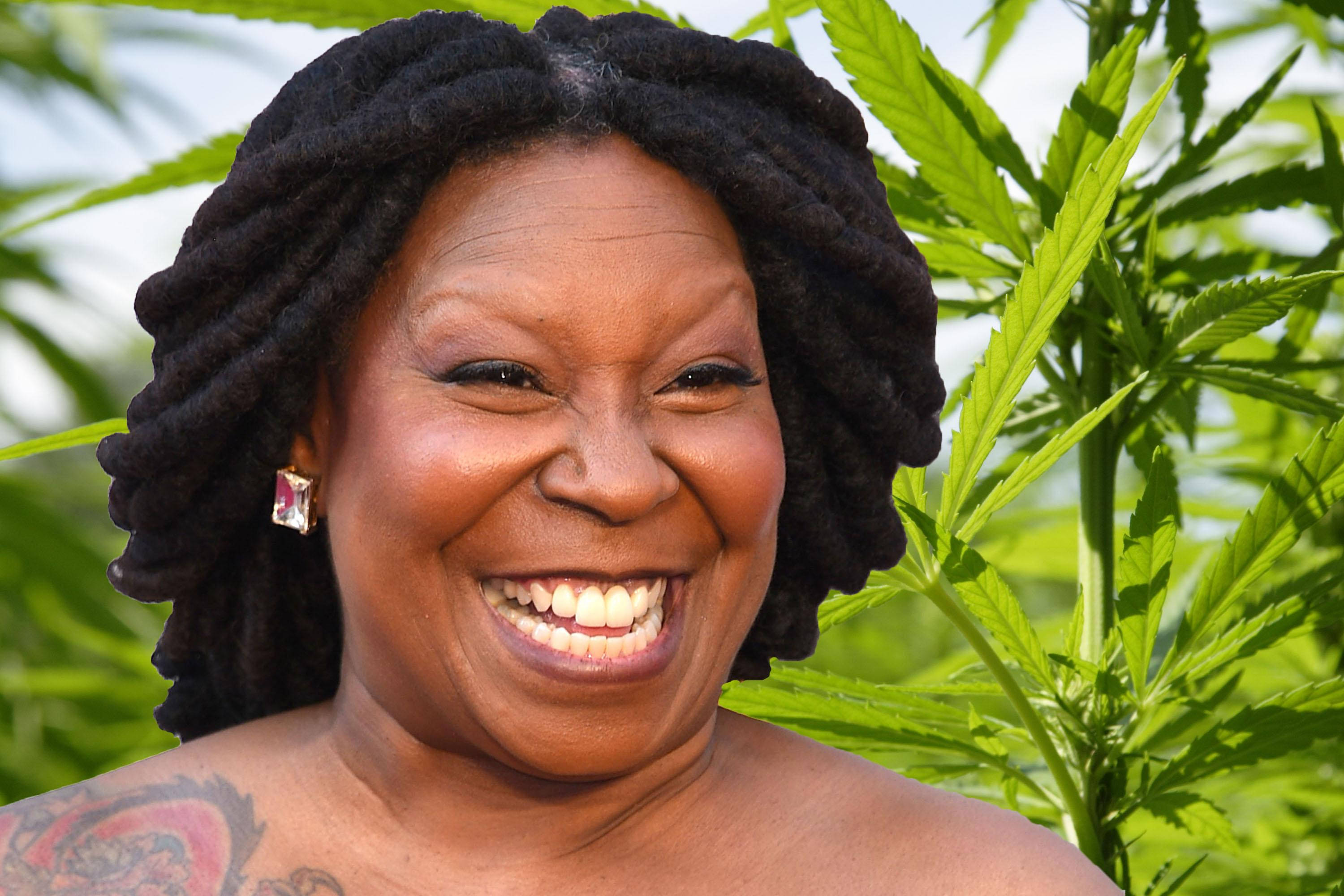 Whoopi Goldberg 肩膀紋身 壁紙 — 一位擁有深色辮子的快樂女性，在明亮的日光下，以茂盛的綠色大麻植物為背景，露出燦爛的笑容。