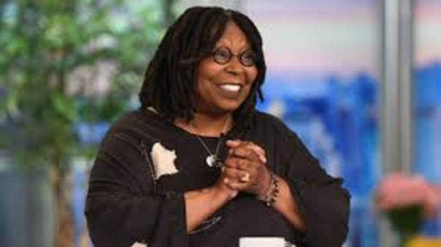 Whoopi Goldberg 微笑 壁紙 — 奧花·雲費在明亮的錄影棚中微笑，背景是模糊的綠色和藍色。