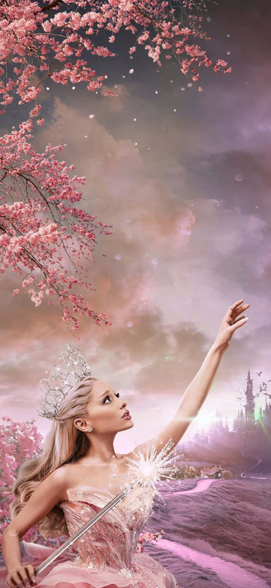 Wicked iPhone 幻想壁紙 壁紙 — 一位身穿粉紅色長裙、頭戴皇冠的女性，在夢幻般的暮色天空下，於盛開的櫻花樹下手持發光的魔杖。