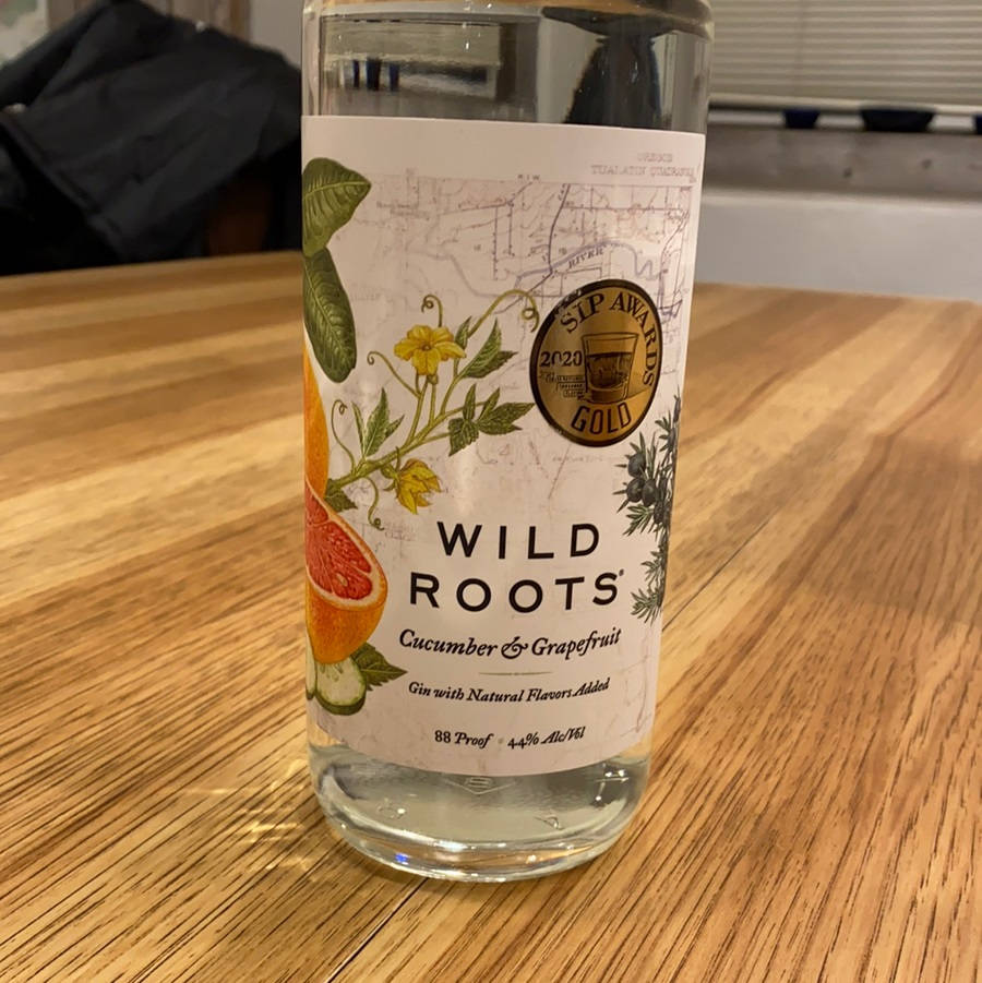 一瓶Wild Roots青瓜西柚味氈酒放在木桌上。