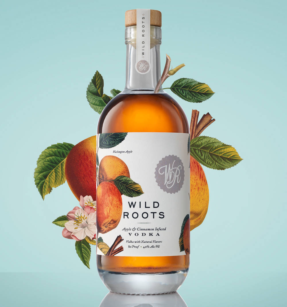 一瓶Wild Roots伏特加，帶有蘋果和肉桂圖案，周圍環繞著樹葉和花朵。