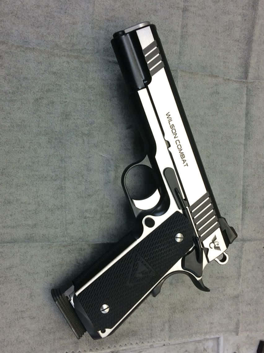 灰色布料上的黑色和銀色 Wilson Combat 手槍。