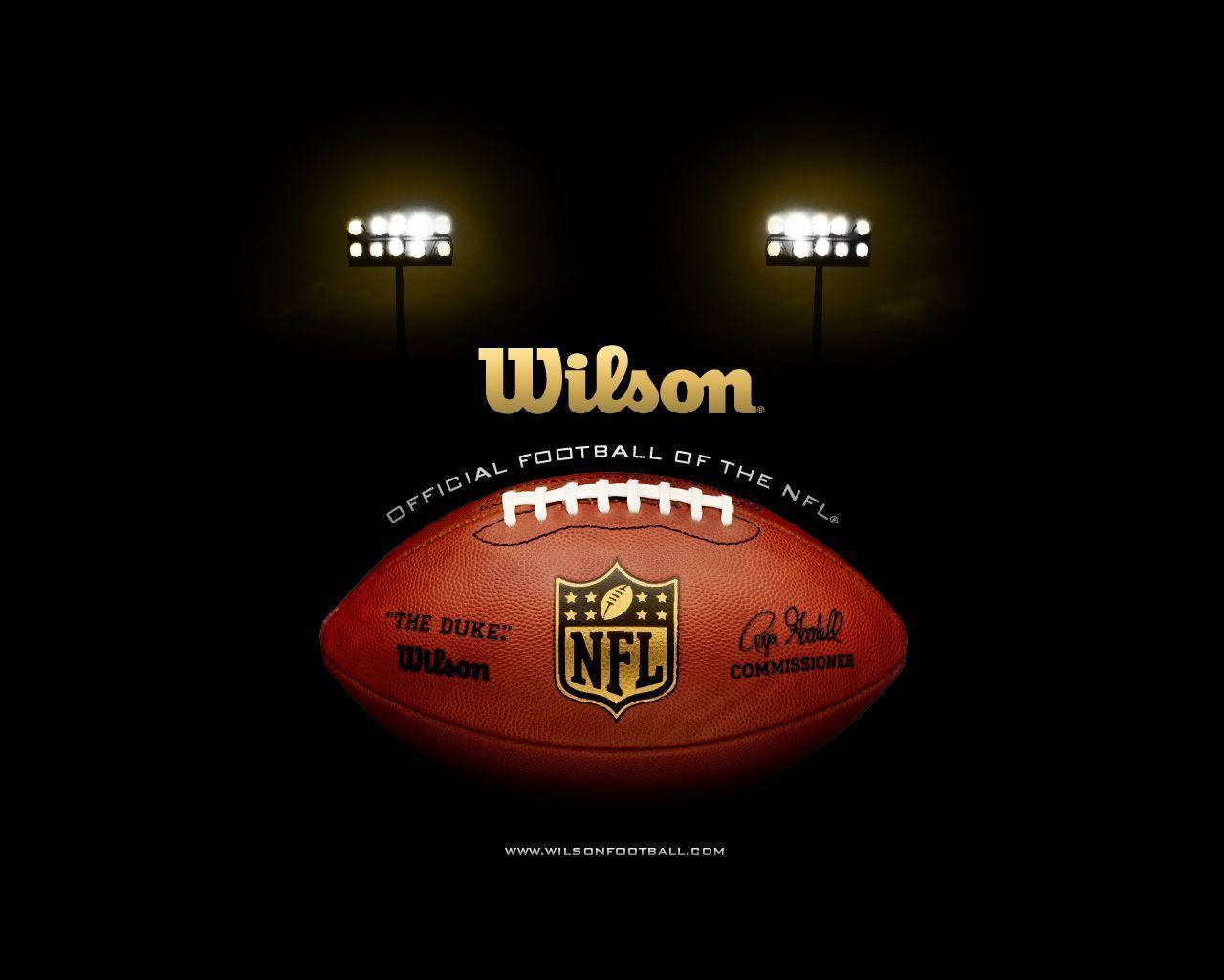 Wilson官方NFL美式足球 壁紙 — Wilson NFL 美式足球在球場燈光下發光，黑色背景，帶有官方品牌標誌。