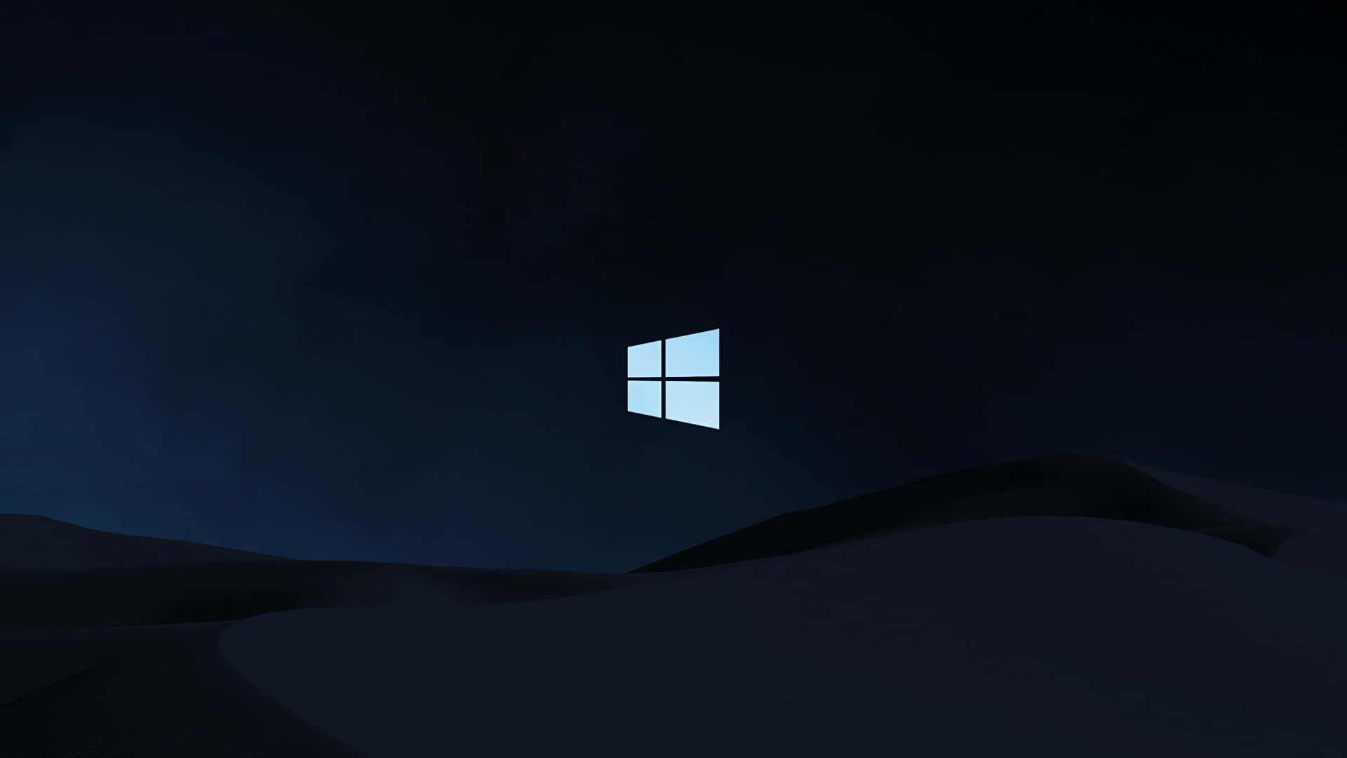 黑暗中的 Windows 10 標誌 壁紙 — 一個發光的藍色Windows標誌漂浮在深色起伏的山丘上，在深邃的夜空下。