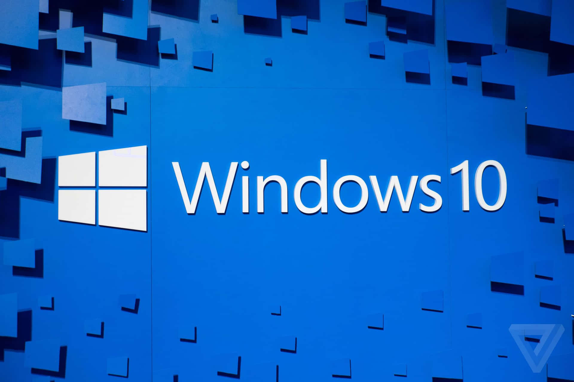 Windows 10標誌在藍色牆壁上，帶有漂浮的幾何形狀。