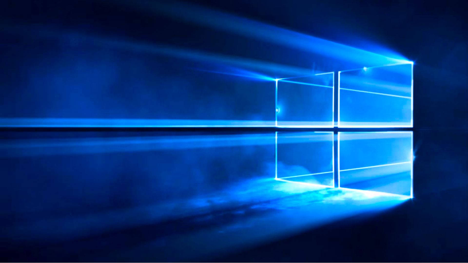 歡迎進入 Windows 10 的世界 壁紙 — 發光的藍色Windows標誌在黑暗背景上明亮閃耀，光線穿過。