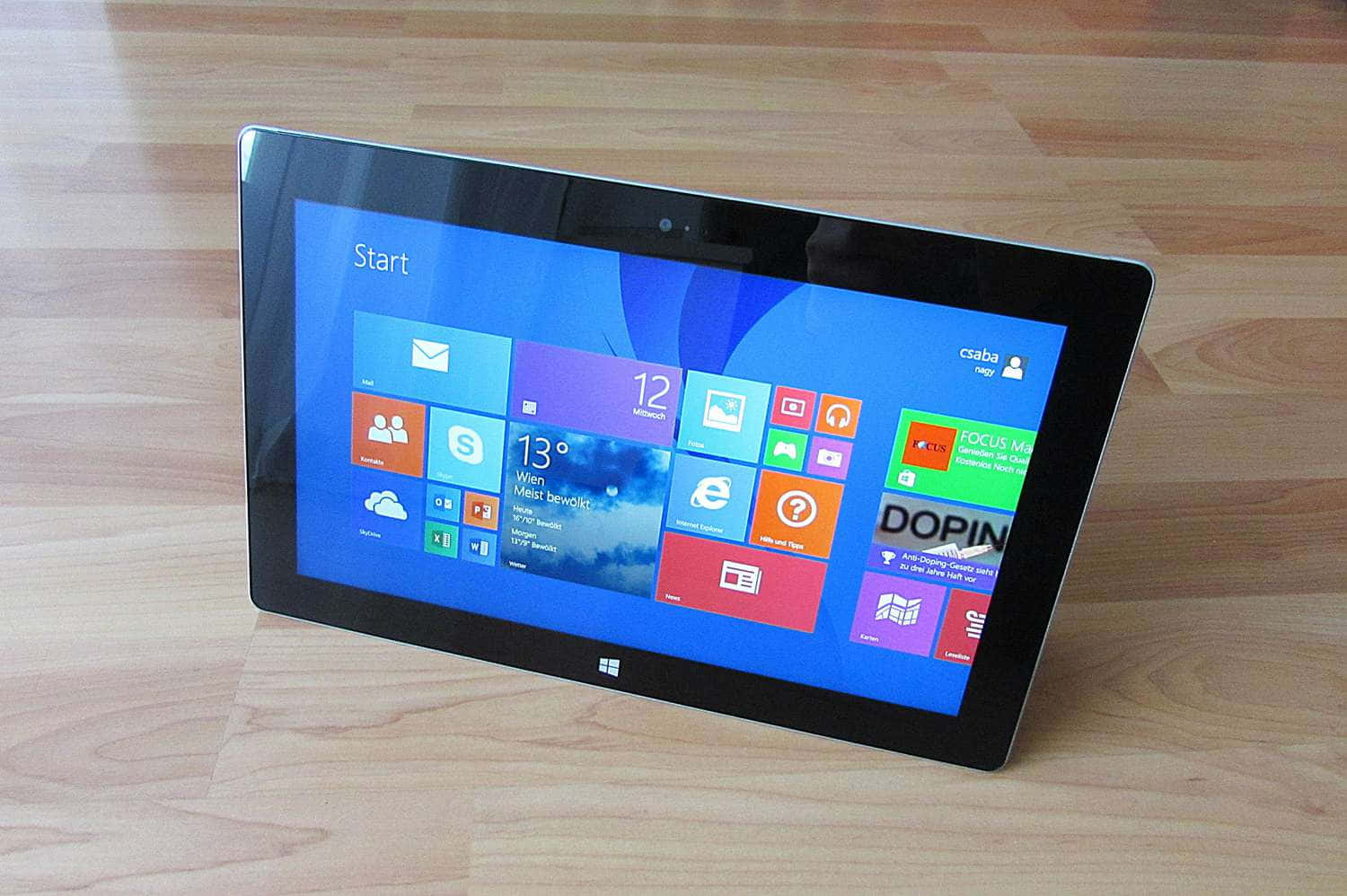 Microsoft Surface 平板電腦顯示 Windows 開始畫面在木地板上