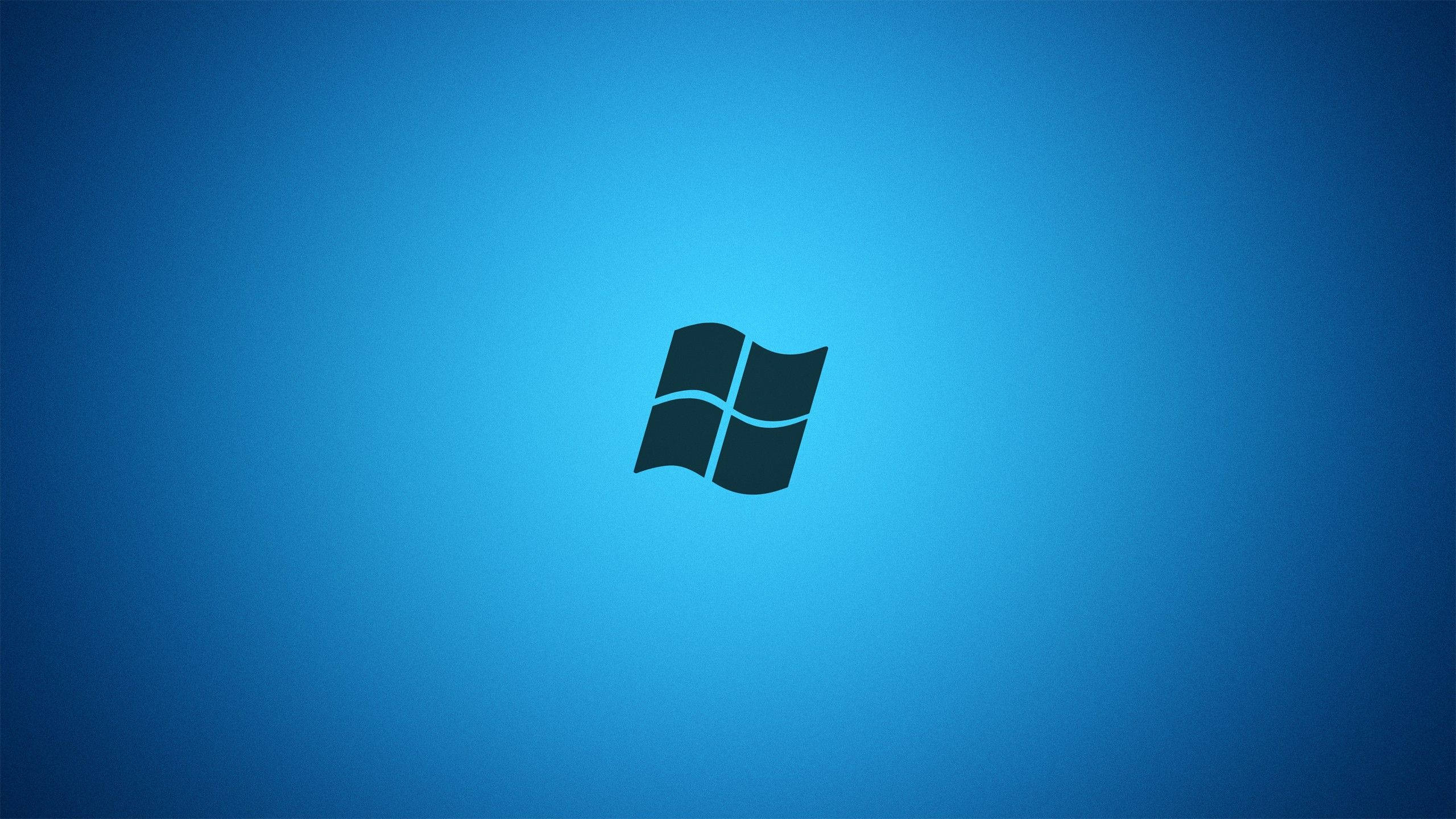 Windows 10 藍色 壁紙 — 一個極簡的黑色Windows標誌，居中在漸變藍色背景上。