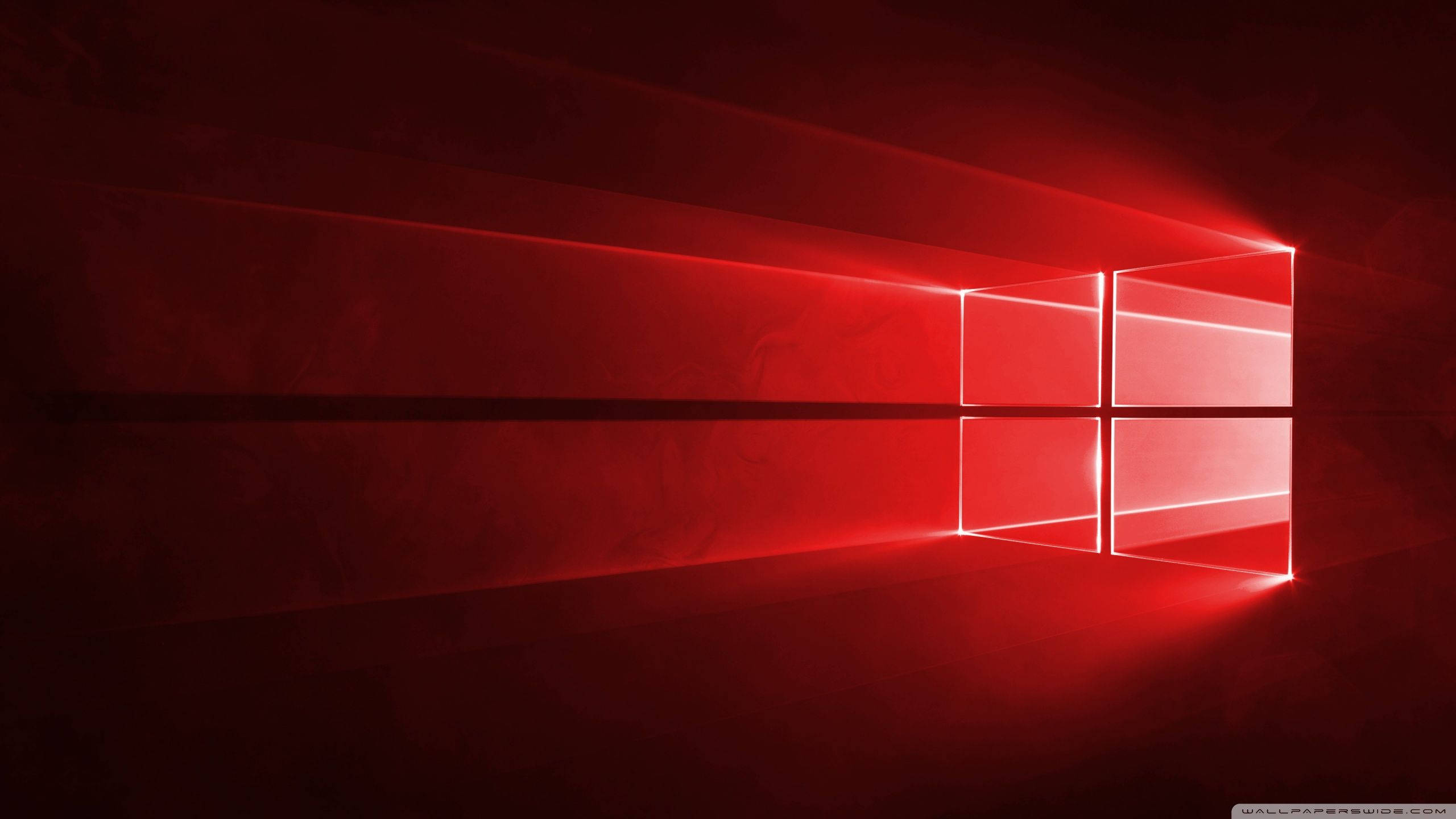 Windows 10 高清紅光標誌 壁紙 — 一個發光的紅色視窗標誌在黑暗紋理表面上投射出耀眼的光束，營造出極簡的數位場景。