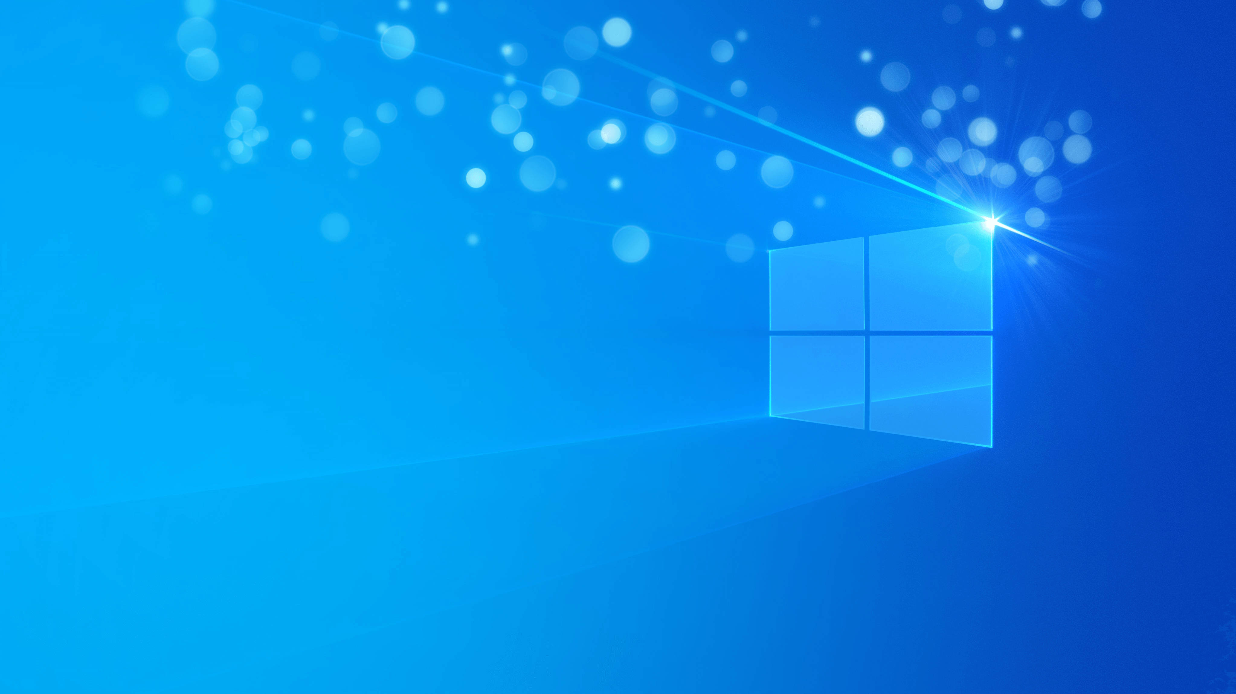 Windows 11 4K 藍色星光 壁紙 — 發光的藍色Windows標誌在漸變藍色背景上閃耀著光線和散景粒子。