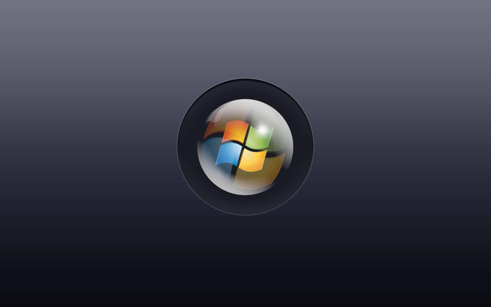 Windows 11 中央按鈕 壁紙 — Windows 標誌圖示置中於一個有光澤的黑色圓圈內，背景為深色漸變。