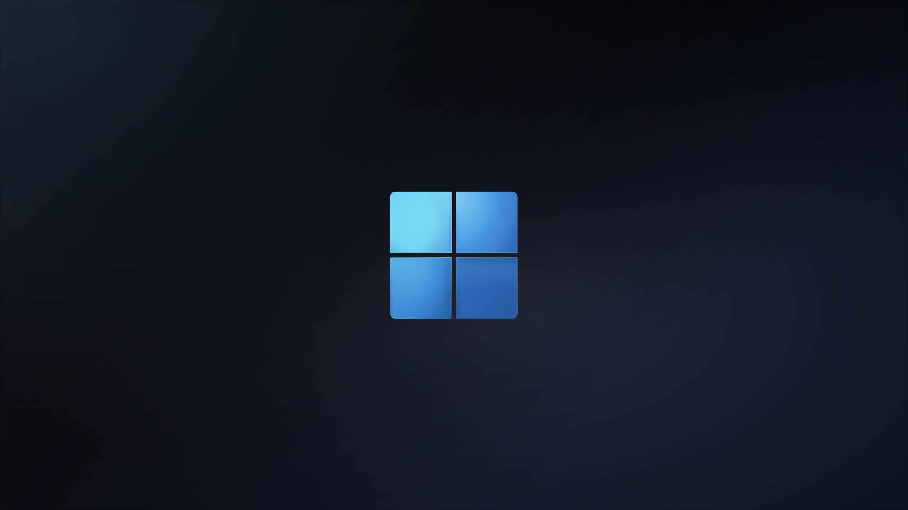 Windows 11 深藍色 壁紙 — 一個發光的藍色Windows標誌，居中放置在帶有細微紋理的深色漸變背景上。