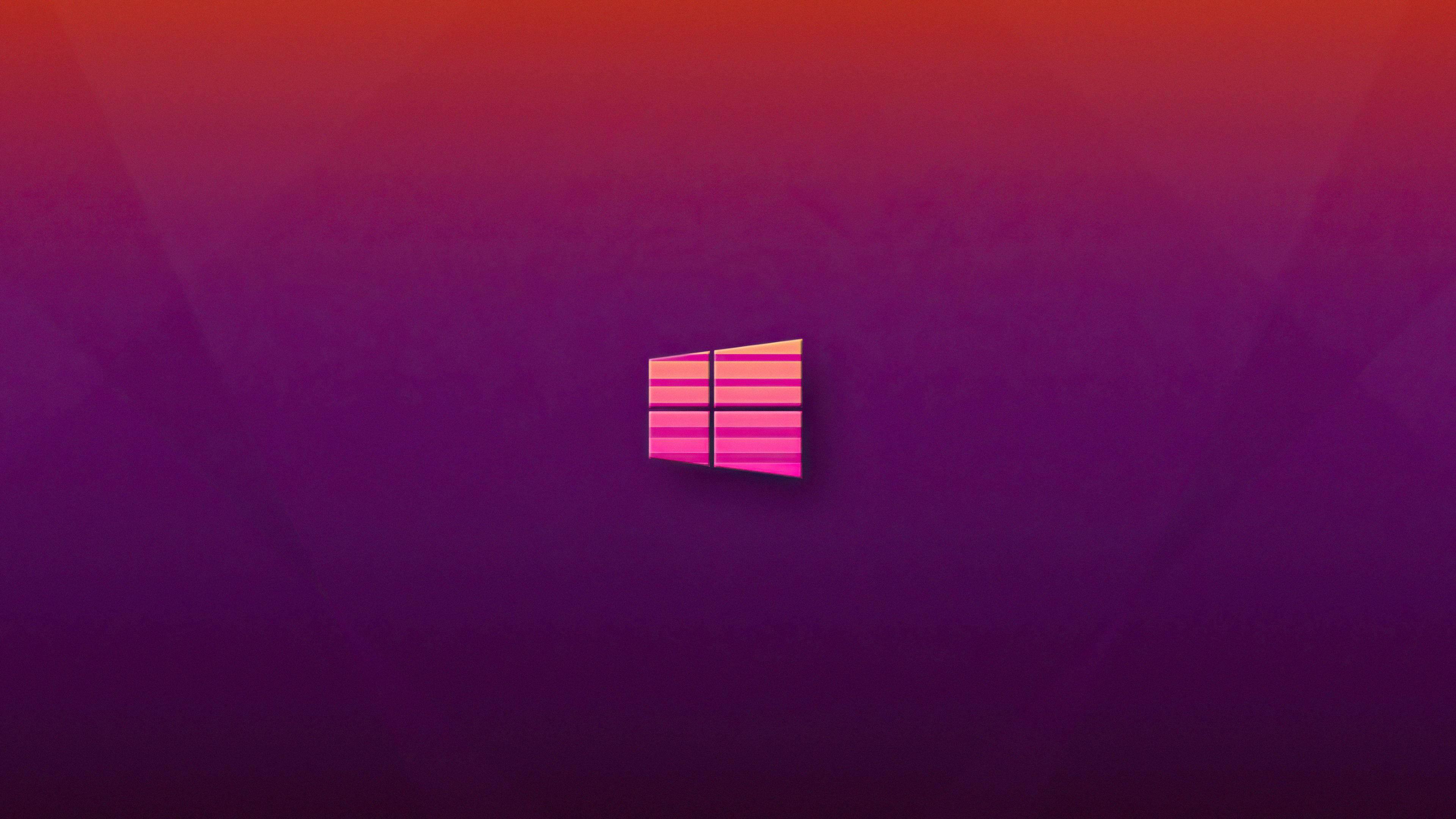 Windows 11 紅紫配色 壁紙 — 一個發光的Windows標誌，居中於漸變紫色和紅色背景上，帶有柔和的光線。