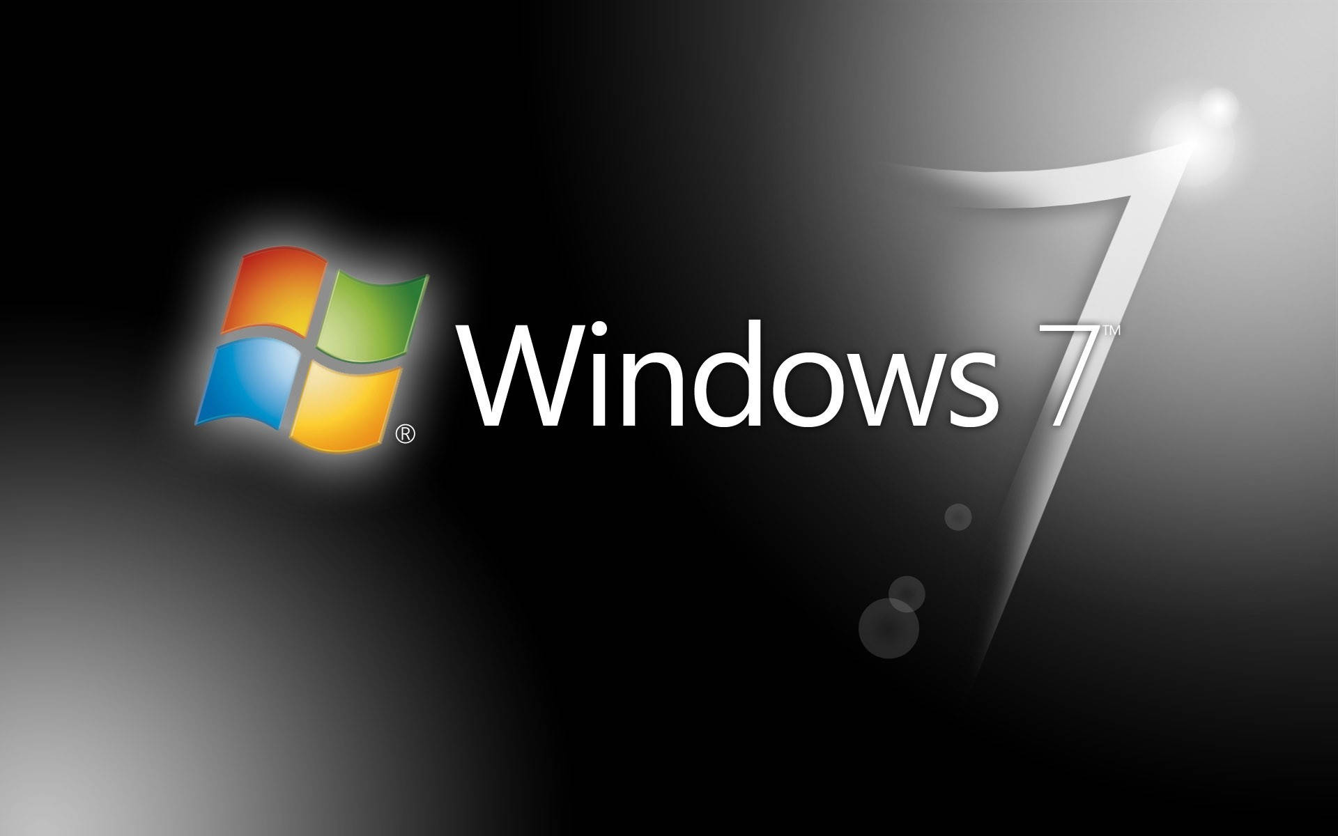 閃耀黑色微軟Windows 7桌面 壁紙 — Windows 7 標誌，帶有彩色四窗格圖標和發光的銀色數字 7，背景為漸變黑色。