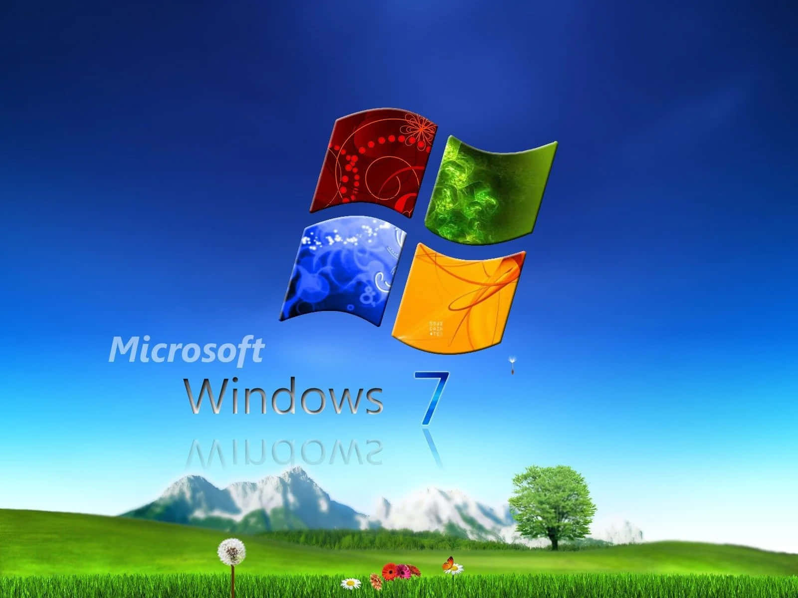 Microsoft Windows 7 壁紙 — Windows 7 標誌漂浮在一個充滿活力的綠色田野上，田野上有山脈和一棵孤樹，天空清澈湛藍。