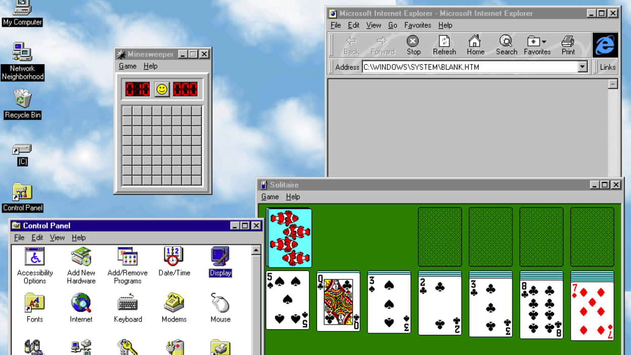 Windows 95 改變計算機的面貌 壁紙 — 經典 Windows 98 桌面，開啟了踩地雷、接龍和 Internet Explorer，背景為藍天桌布。