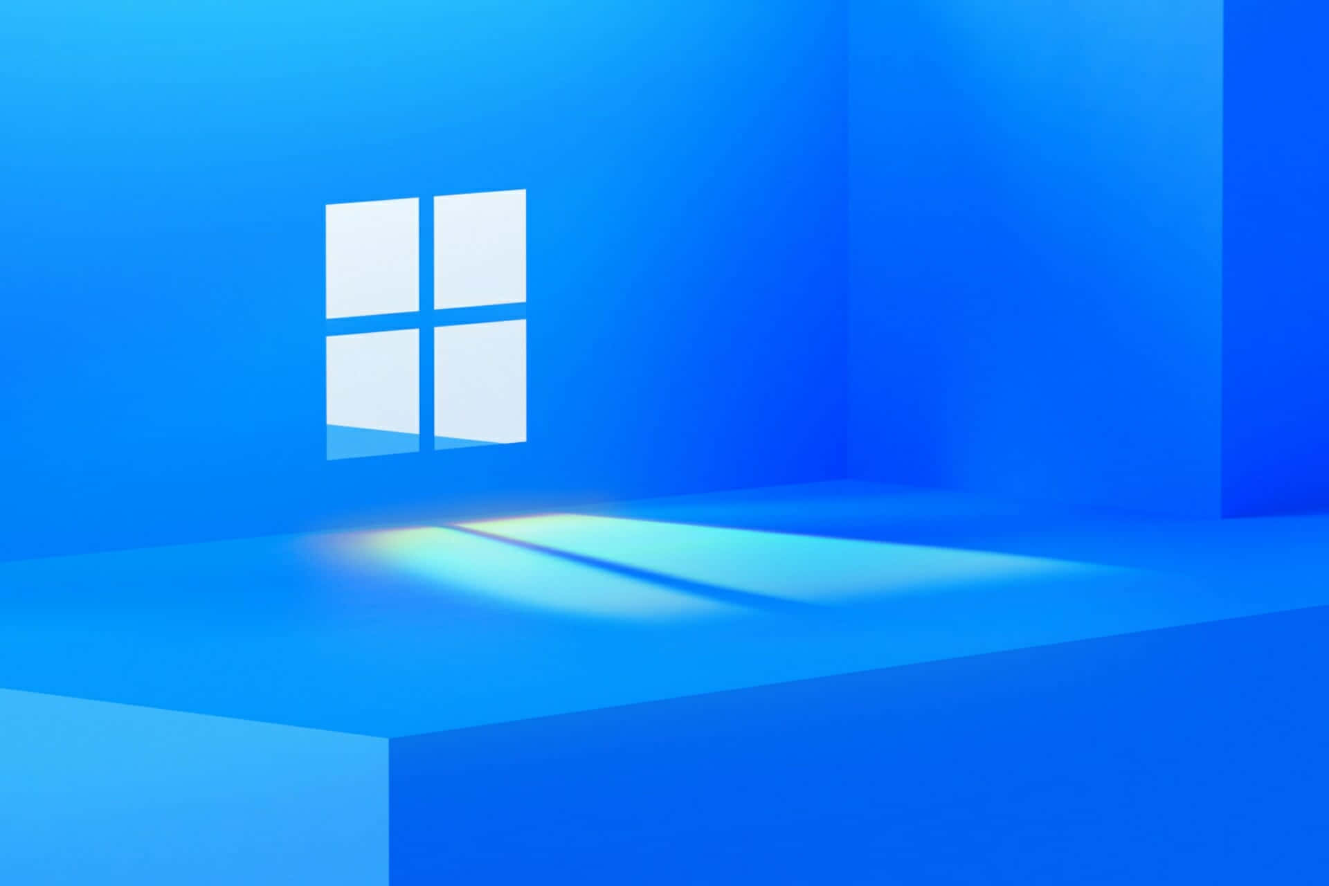 Windows 預設 - 色彩繽紛抽象壁紙 壁紙 — 一個簡約的藍色房間，發光的Windows標誌在地板上投射出柔和的光線。