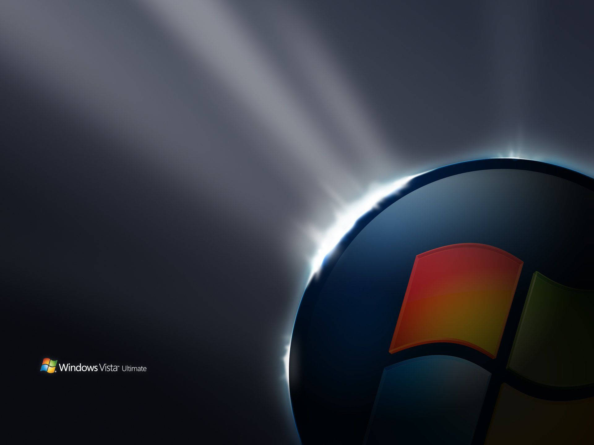 Windows Vista 標誌 壁紙 — Windows Vista 標誌在深色漸變背景上散發出耀眼的光芒。