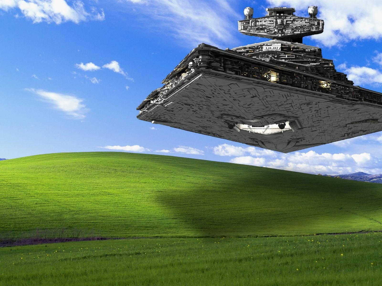 Windows XP經典桌面主題 壁紙 — 一艘巨大的星際驅逐艦在明亮的藍天下，飄浮在充滿活力的綠色山丘上，天空中有蓬鬆的雲朵。
