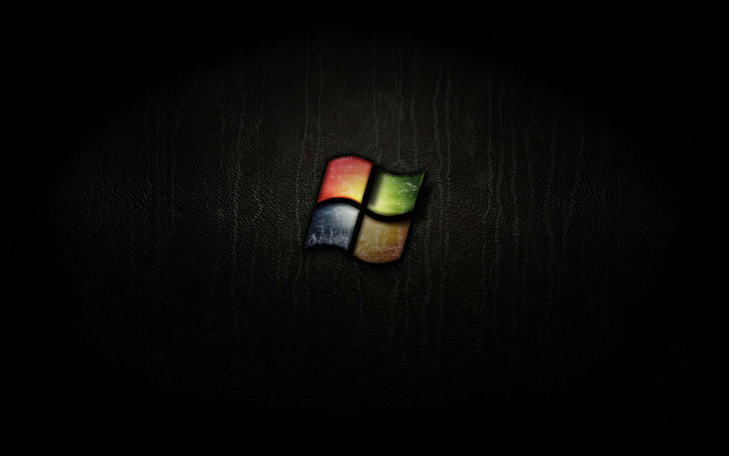 Black Windows 桌布 壁紙 — Windows 標誌在昏暗燈光下，於帶有紋理的黑色皮革背景上柔和發光。