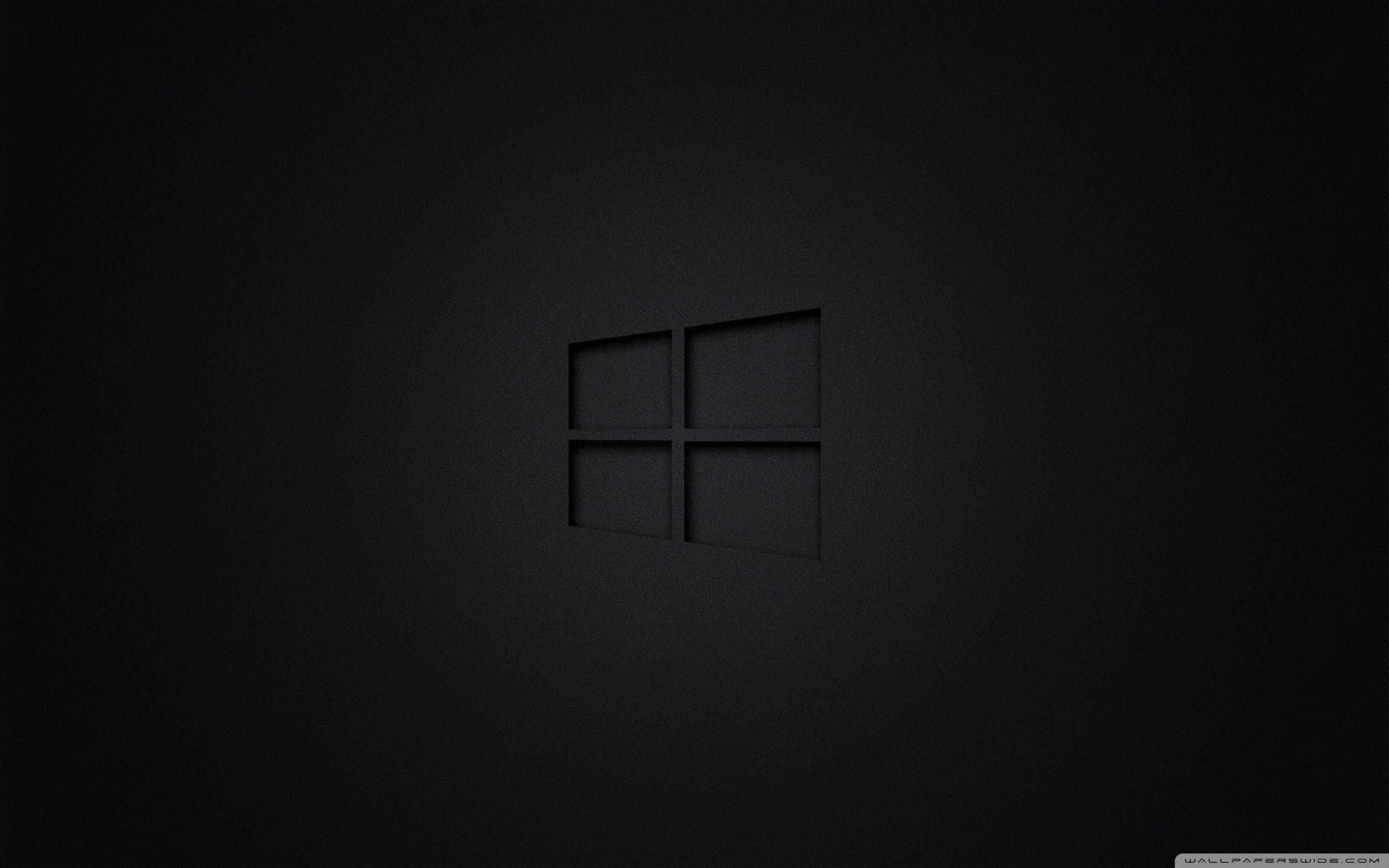 Windows 黑色極簡 壁紙 — 一個極簡的黑色Windows標誌，在柔和的環境光線下，微妙地壓印在有紋理的深色表面上。