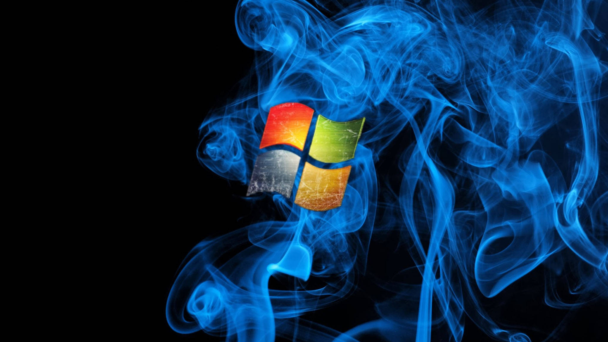 Windows標誌藍焰 壁紙 — Windows 標誌從旋轉的藍色煙霧中浮現，背景為黑色且帶有粗糙質感。