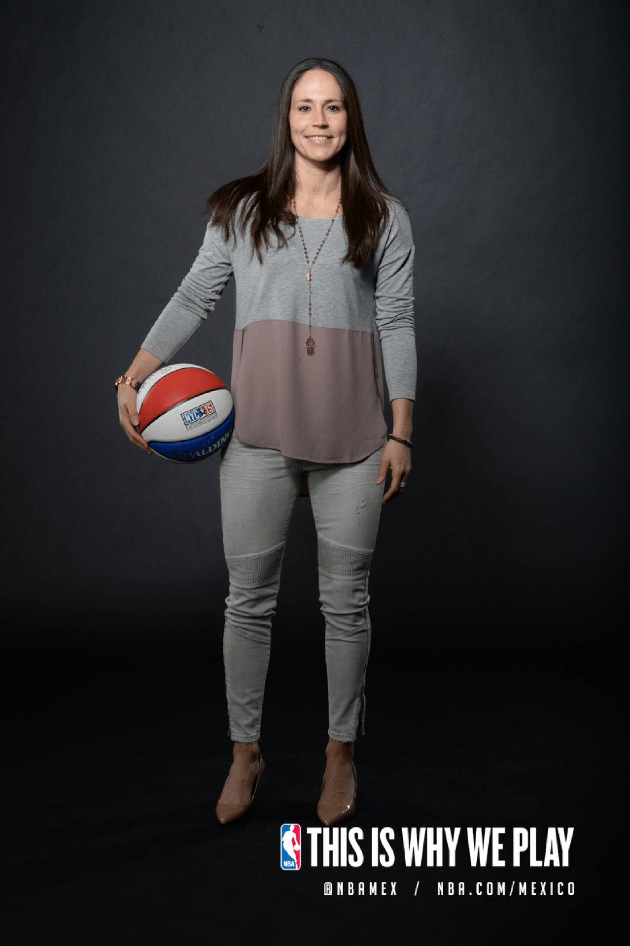 女性在工作室肖像中為NBA Mexico活動拿著籃球。
