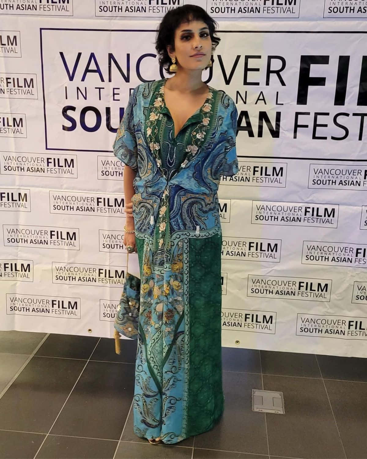Agam Darshi 桌布 壁紙 — 一位身穿藍綠色花卉長裙的女性在溫哥華國際南亞電影節上自信地擺姿勢。
