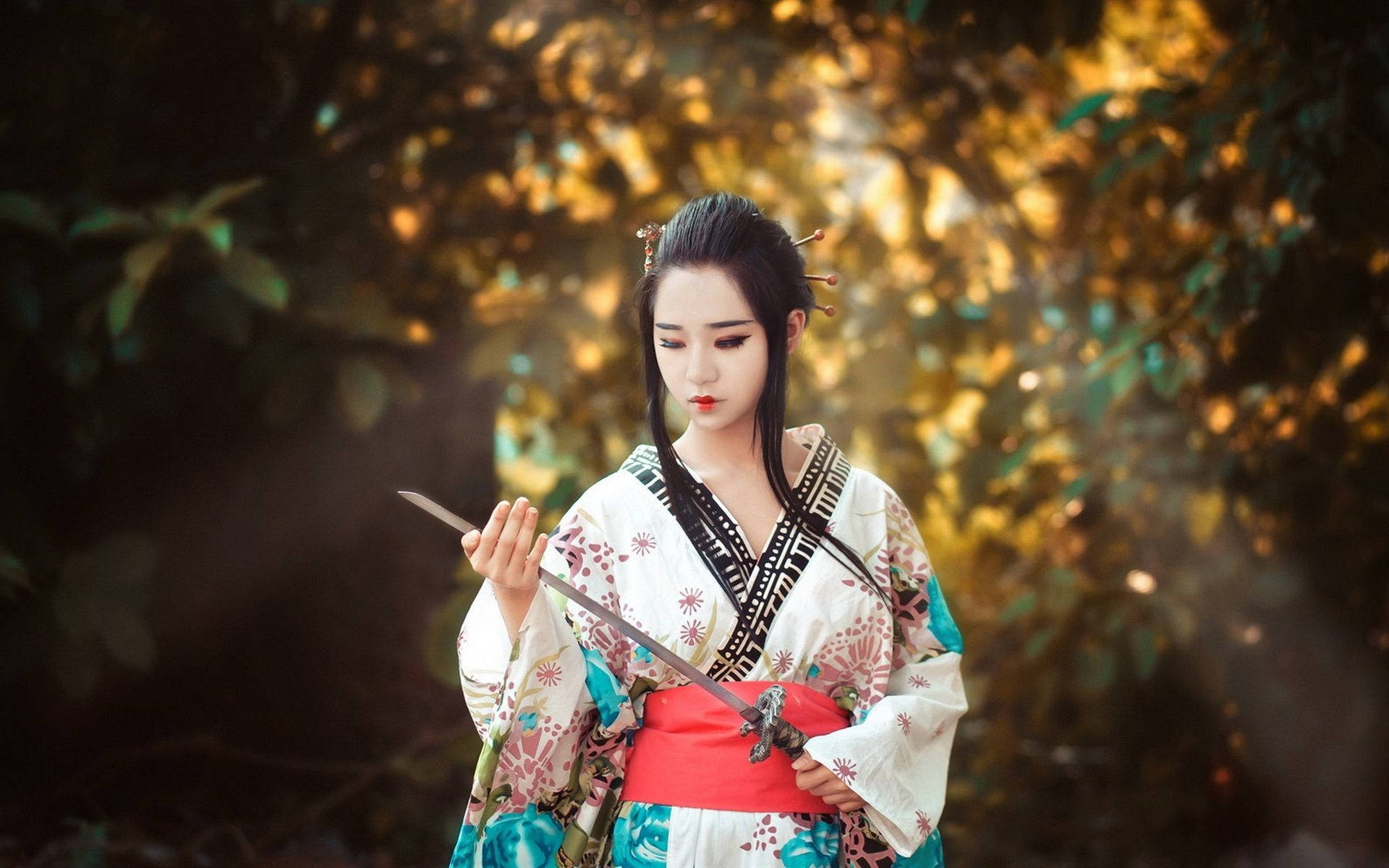 穿著和服的女性在秋日森林的黃金時刻手持刀劍。