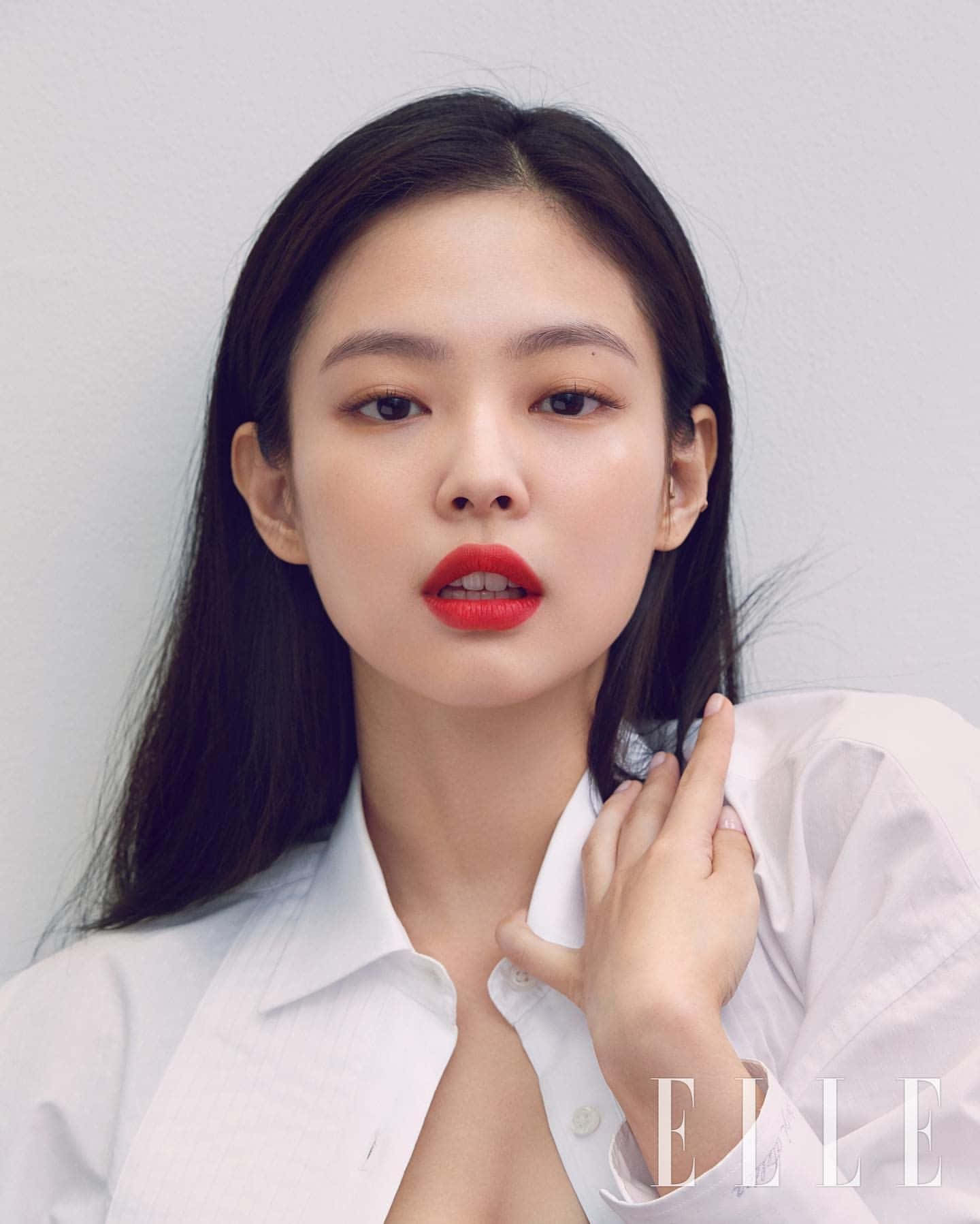 Jennie Kim 為 Elle Magazine 拍攝寫真 壁紙 — 一位深色頭髮、大膽紅唇的女性，穿著白色襯衫，在純色背景前直視鏡頭。